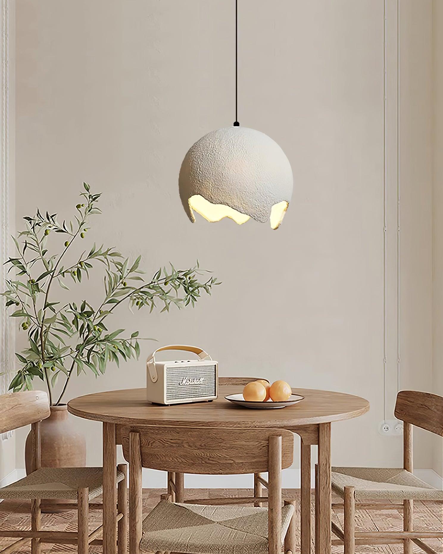 Textured pendant over a round table and plants
