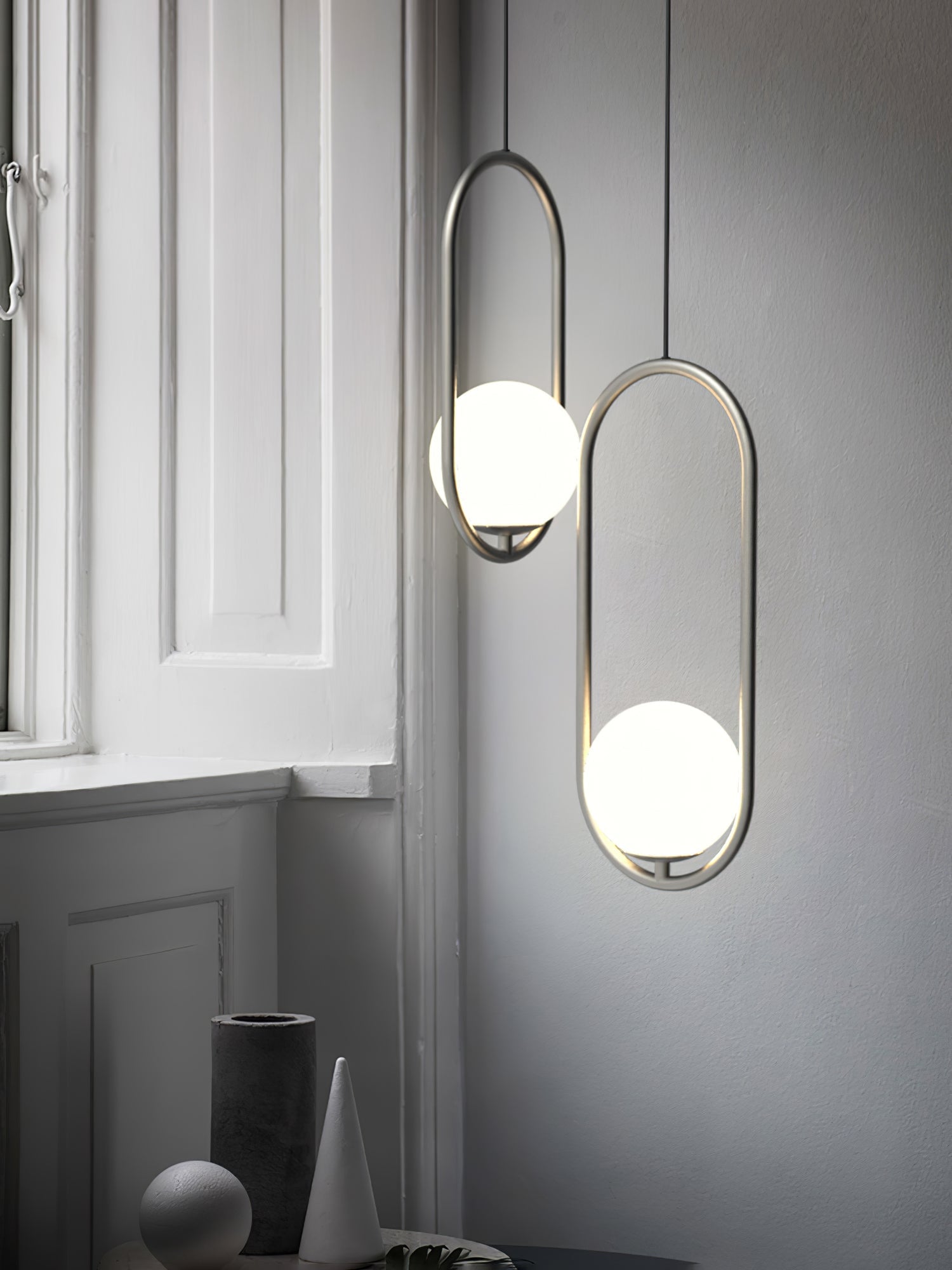 Two silver-coloured oval frames beside a window