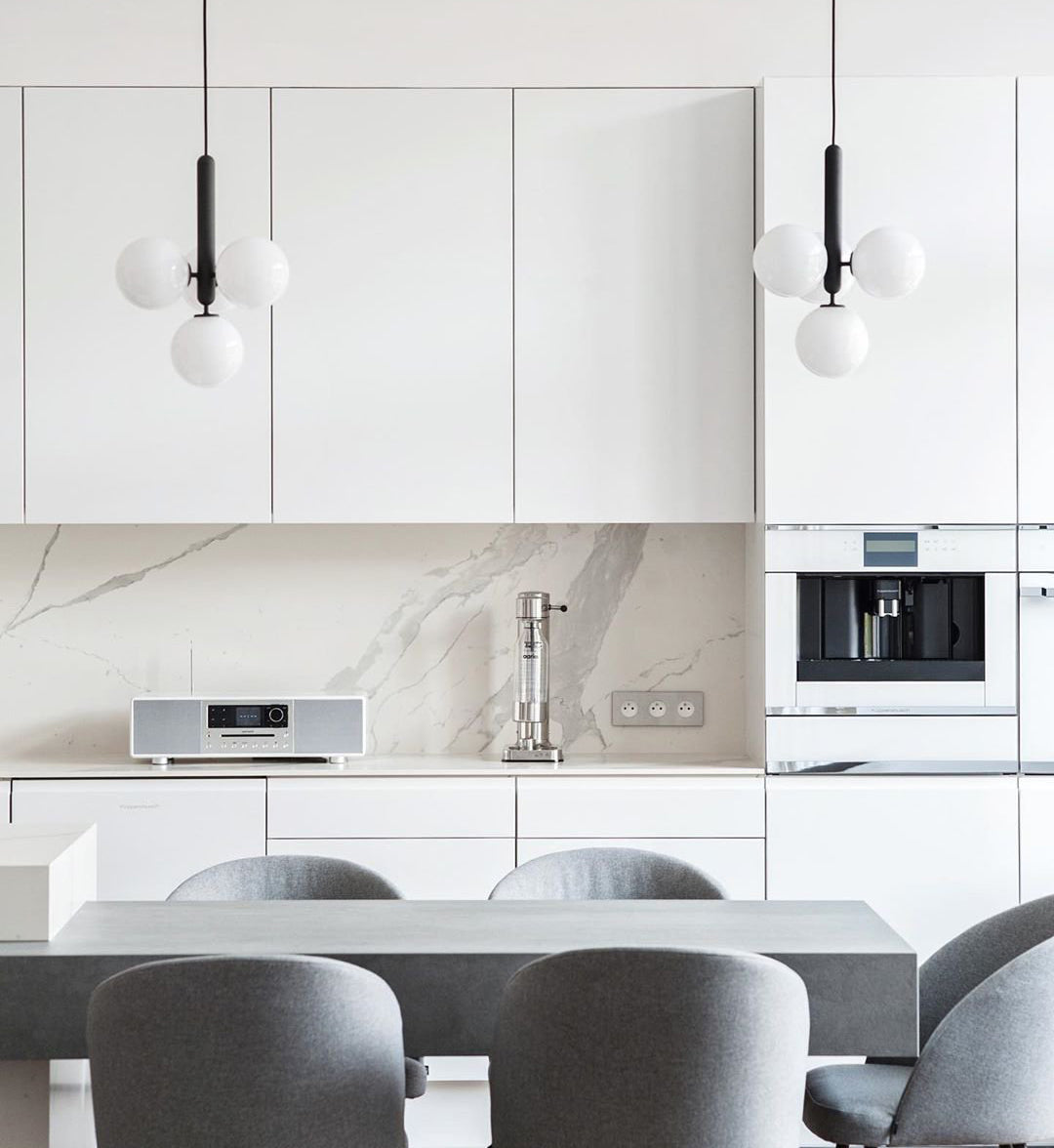 Two white globe clusters above a kitchen table