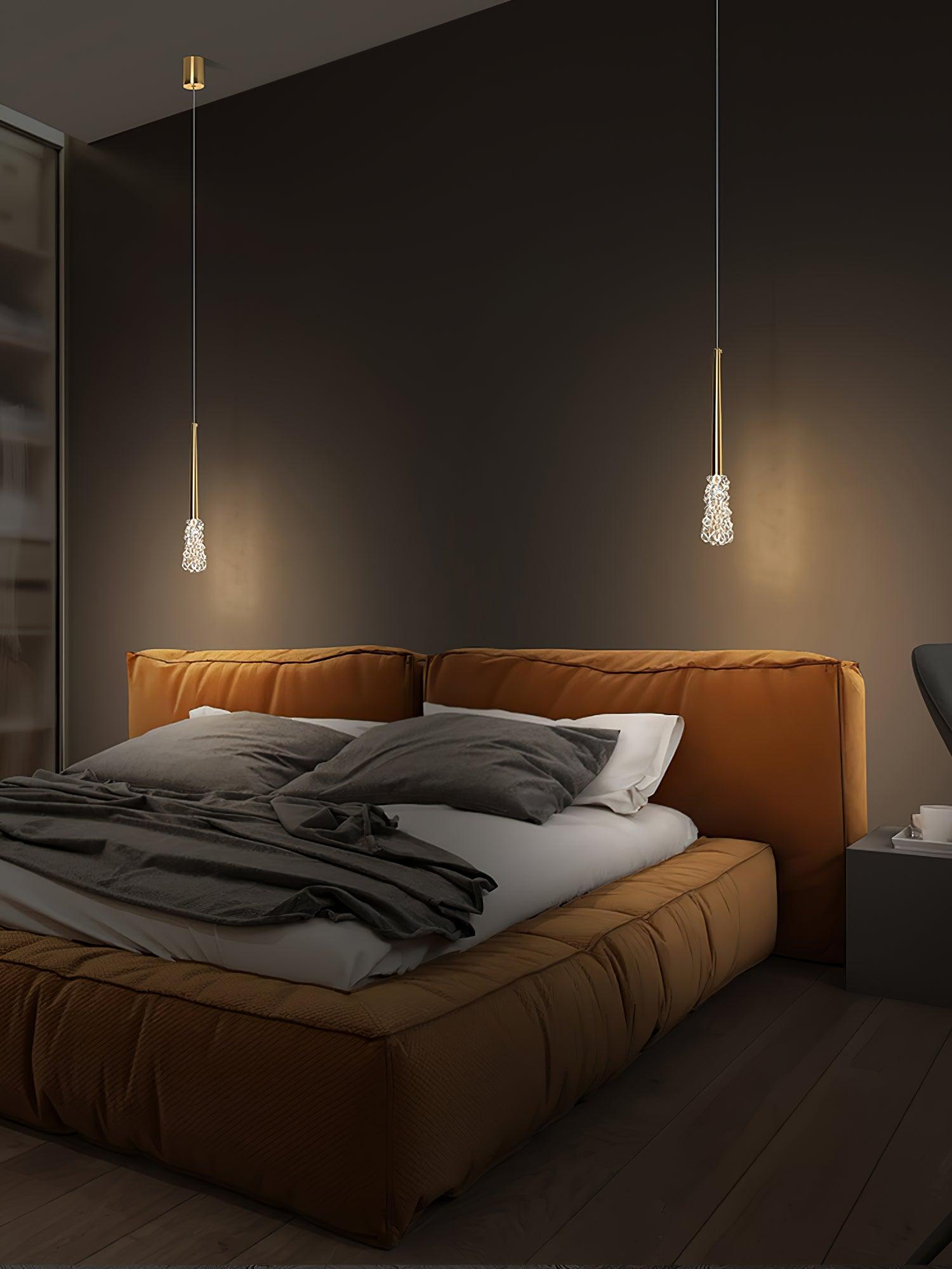 Gold single pendants above bedside furniture