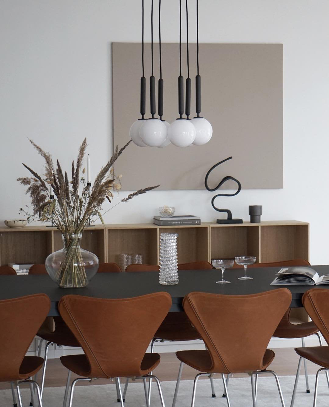 White-globe pendant group with black stems over a table