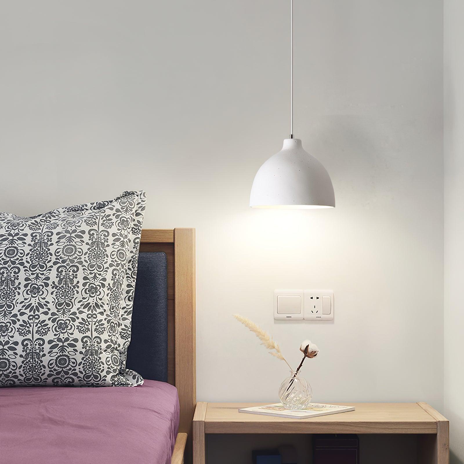 White bowl pendant over a bedside table