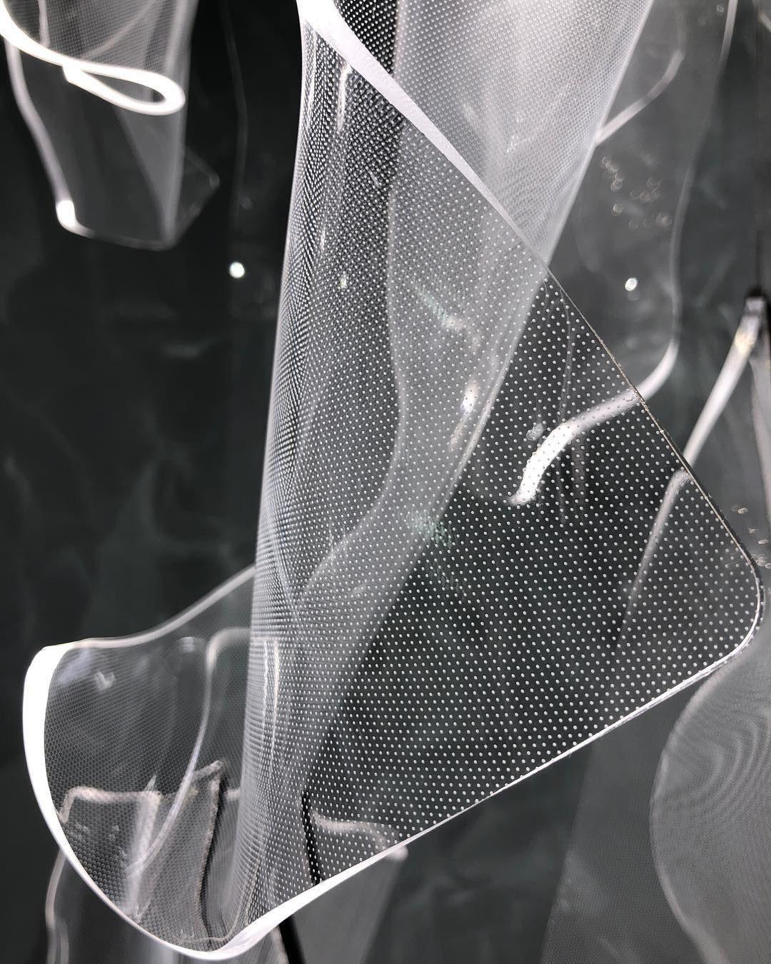 Close-up of fine dots on a curved transparent acrylic sheet