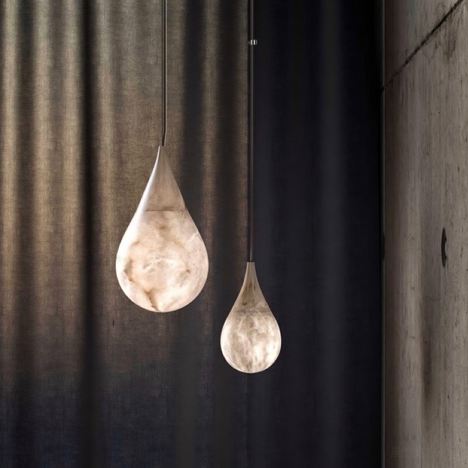Two teardrop pendants near dark curtains