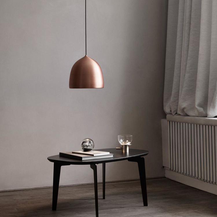 Copper bell pendant above a small dark table