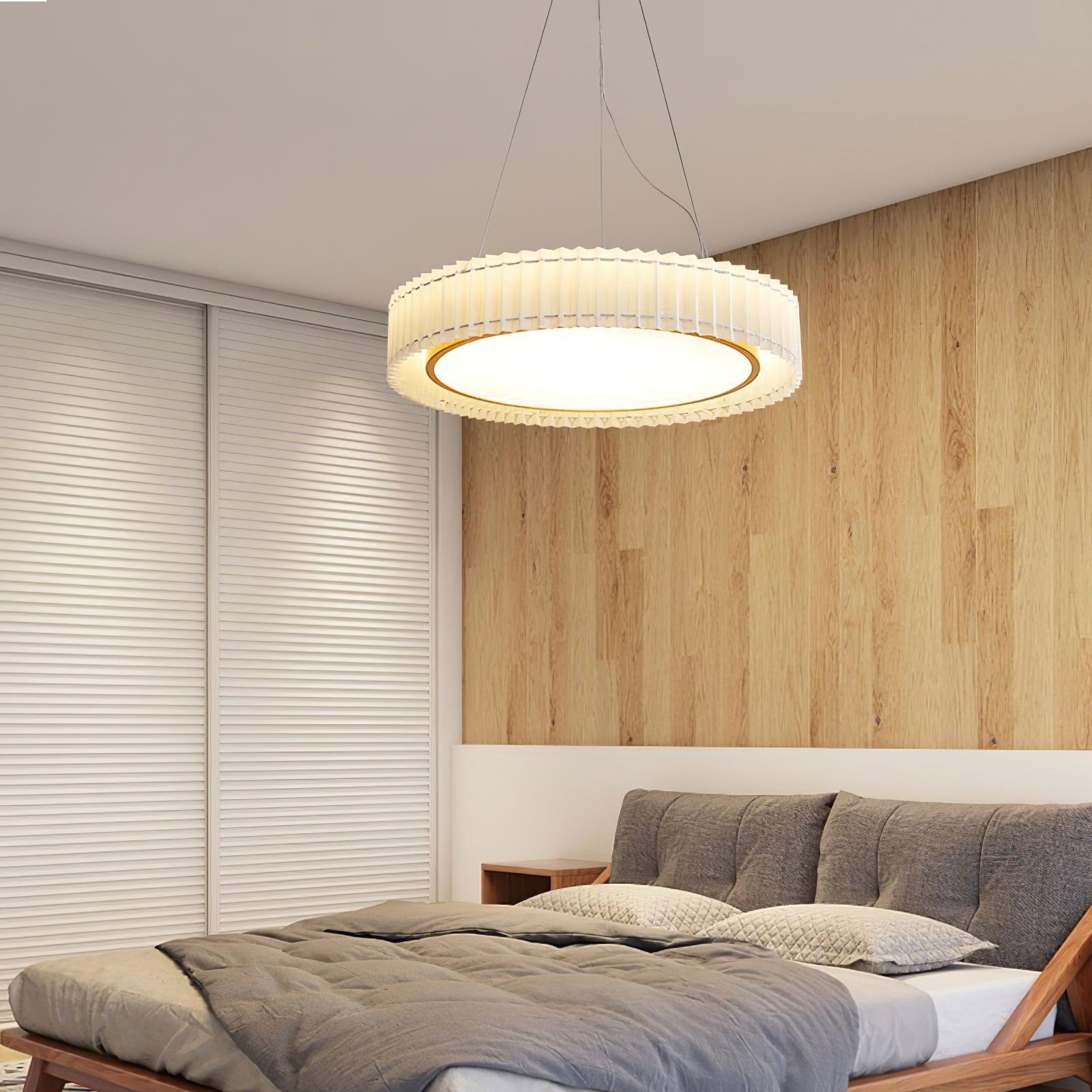 Large lit pleated pendant over a gray bed with timber frame, wood wall and white louvered doors