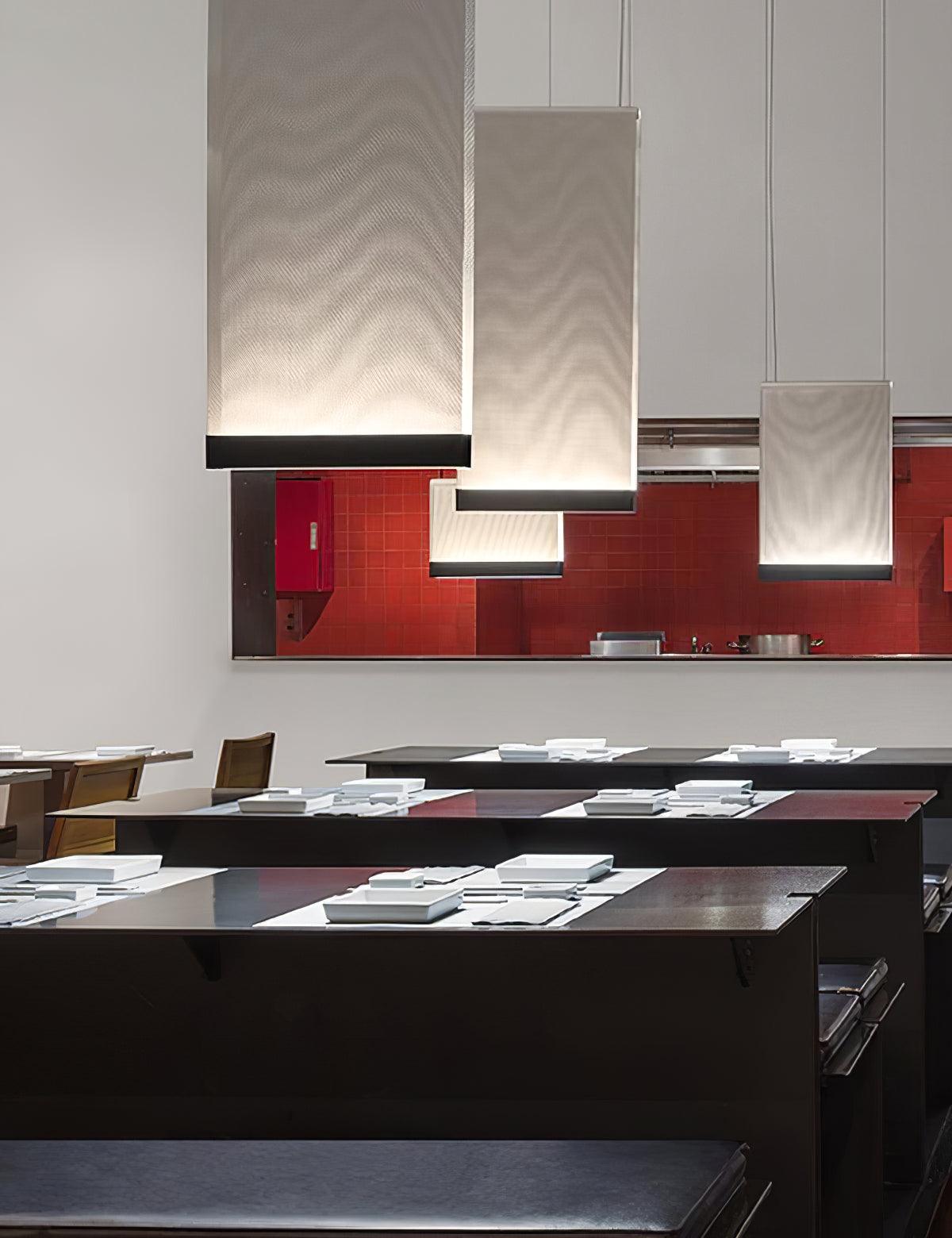 Fabric panel pendant lights above tables laid with place settings