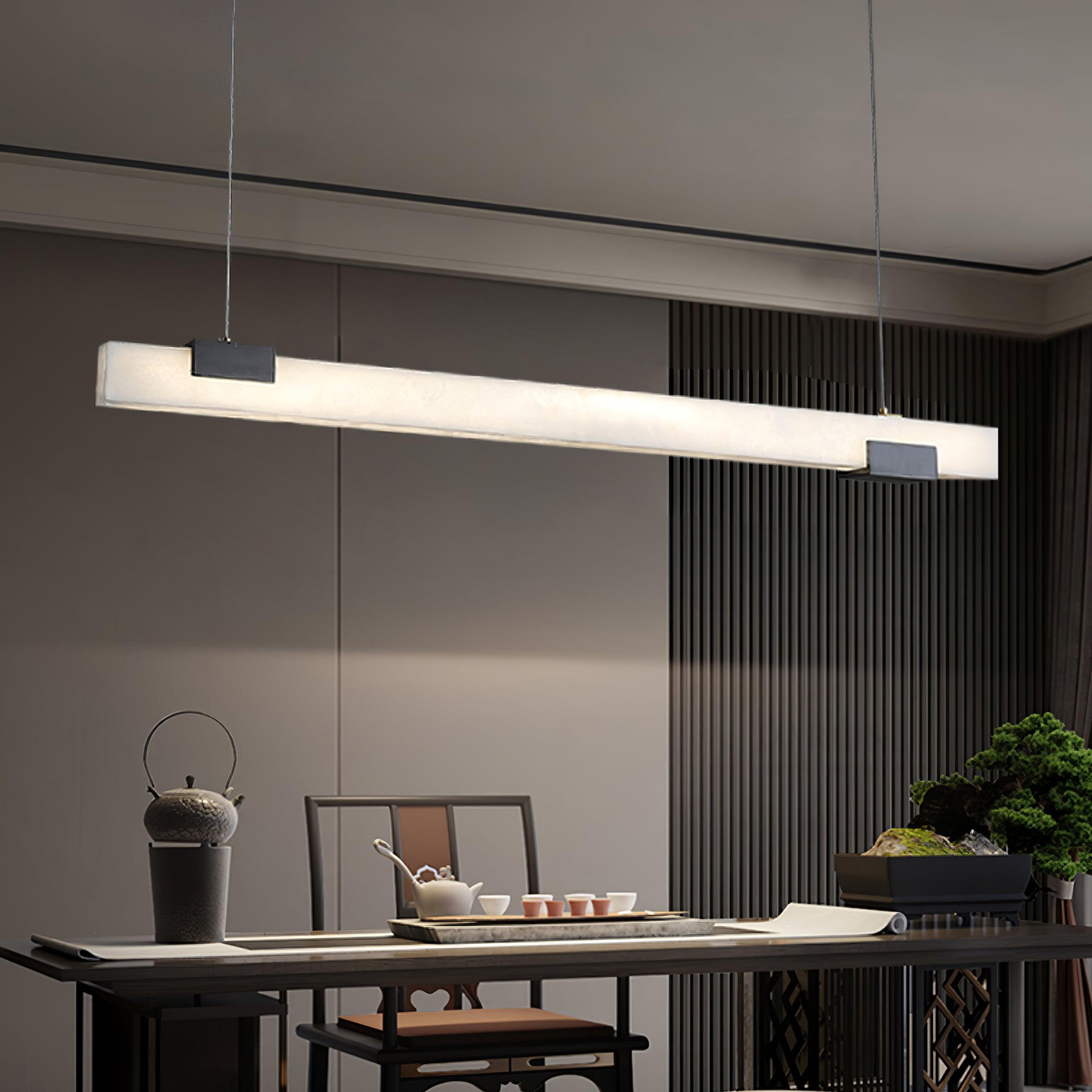 White bar pendant over tea table with raised kettle, teapot, cups and bonsai against slatted wall