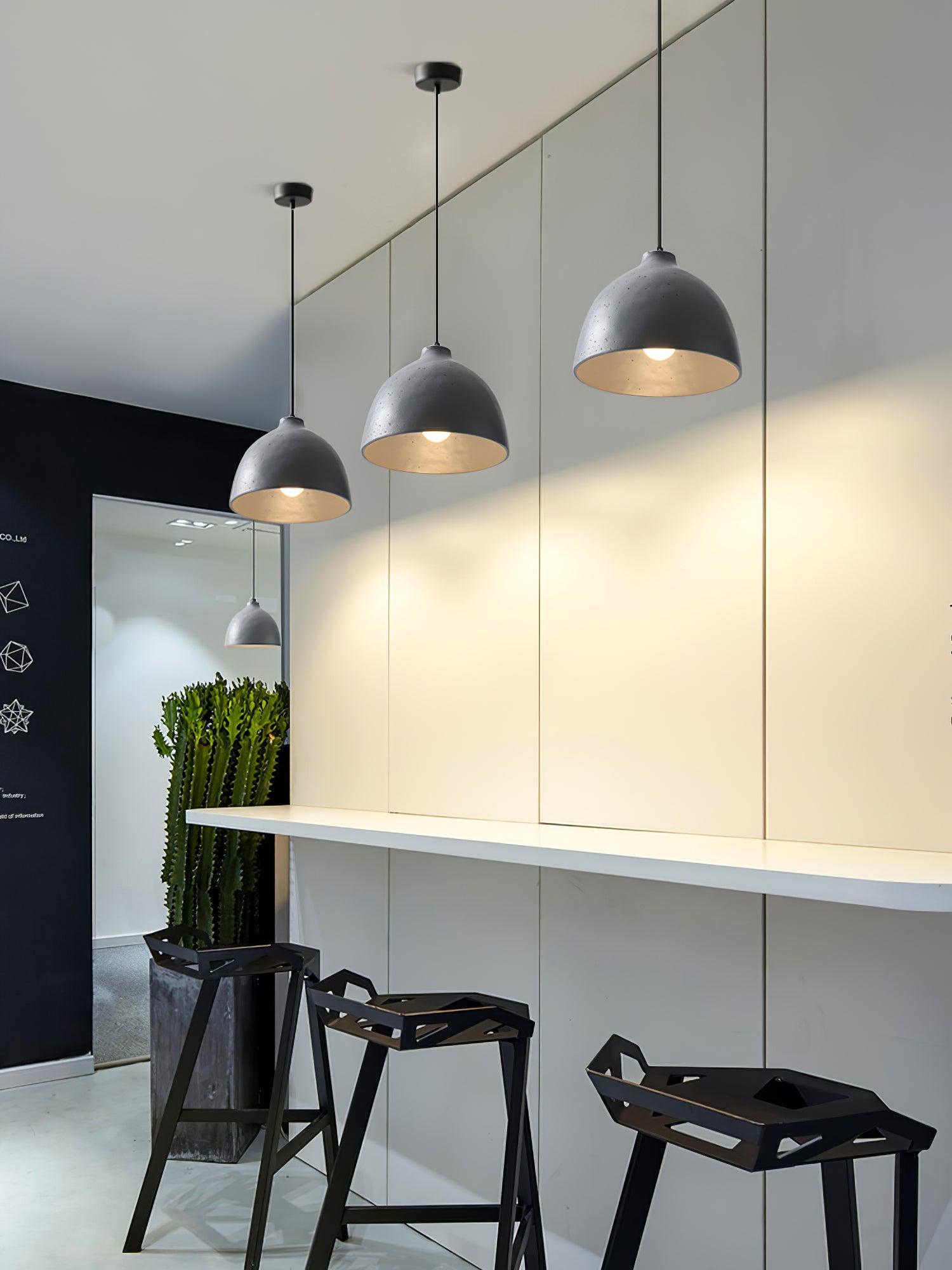 Grey pendants above a counter with black stools