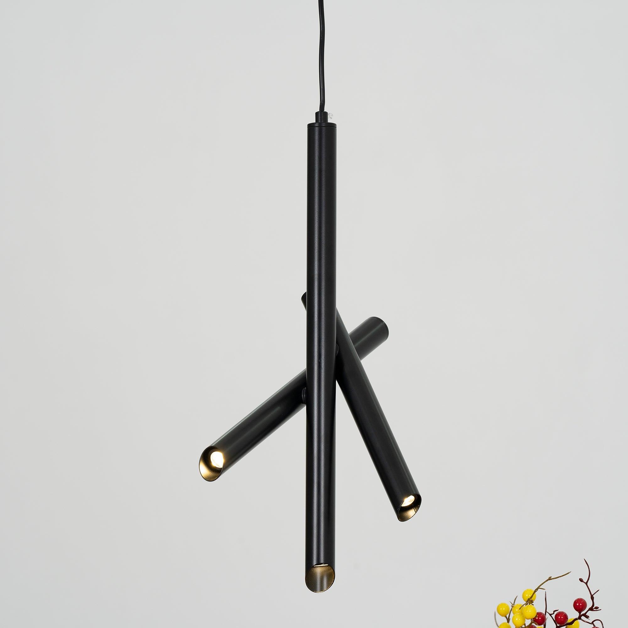 Black Tubes pendant viewed from below with glowing ends above a vase of flowers
