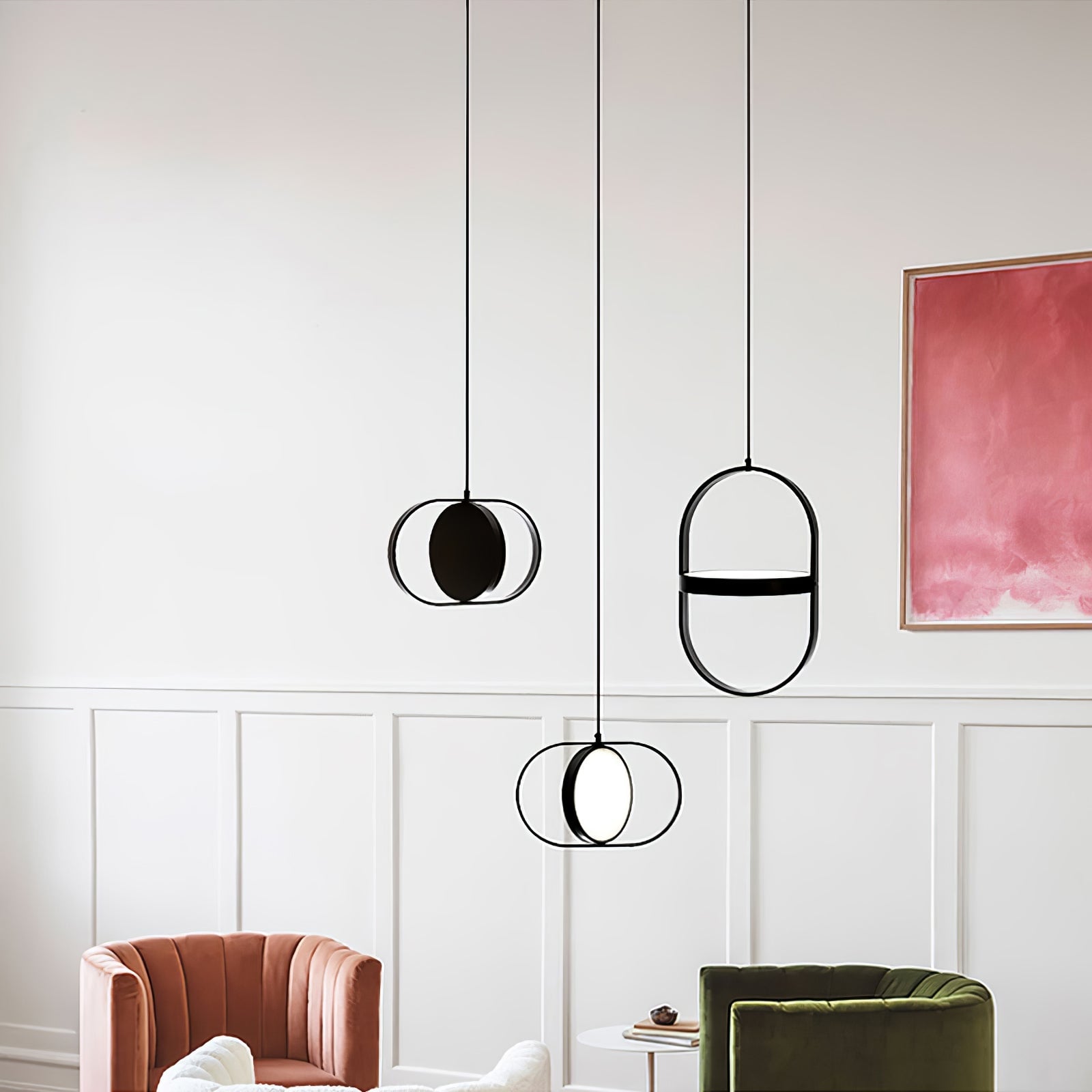 Three black KUU pendants above colourful armchairs