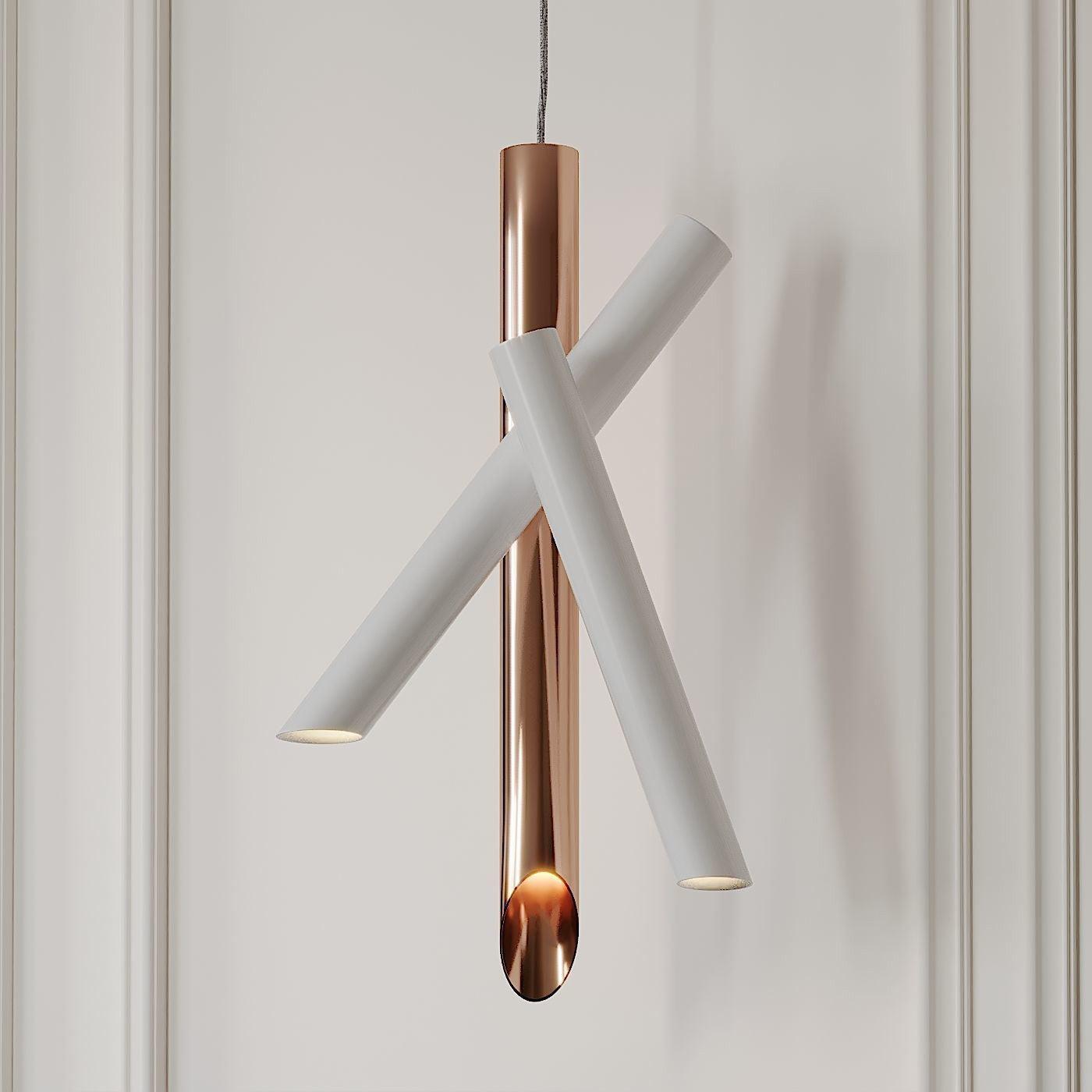 Closer view of the crossing white arms and rose-gold vertical tube of a lit Tubes pendant