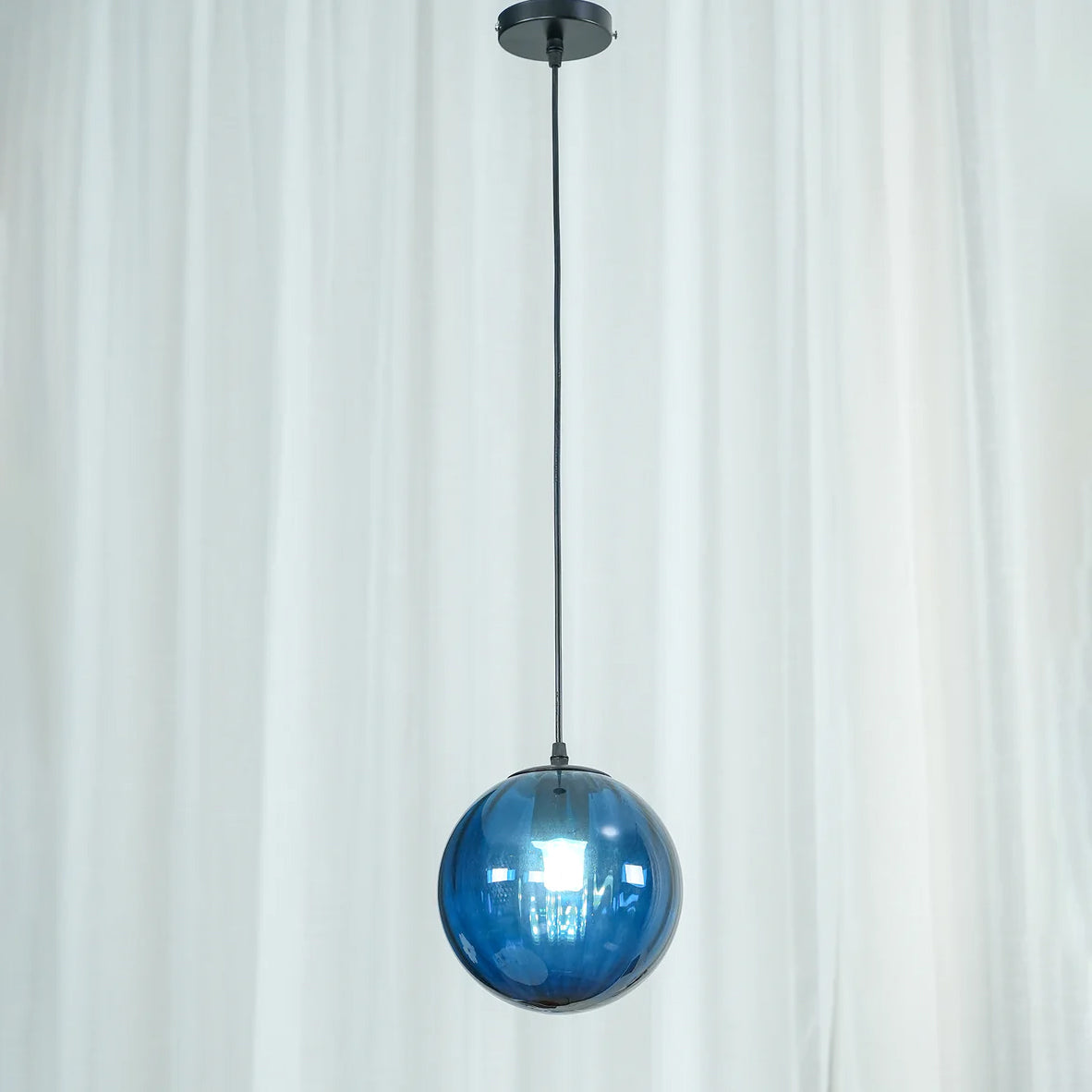 Paola pendant light with a coloured glass globe and small metal cap