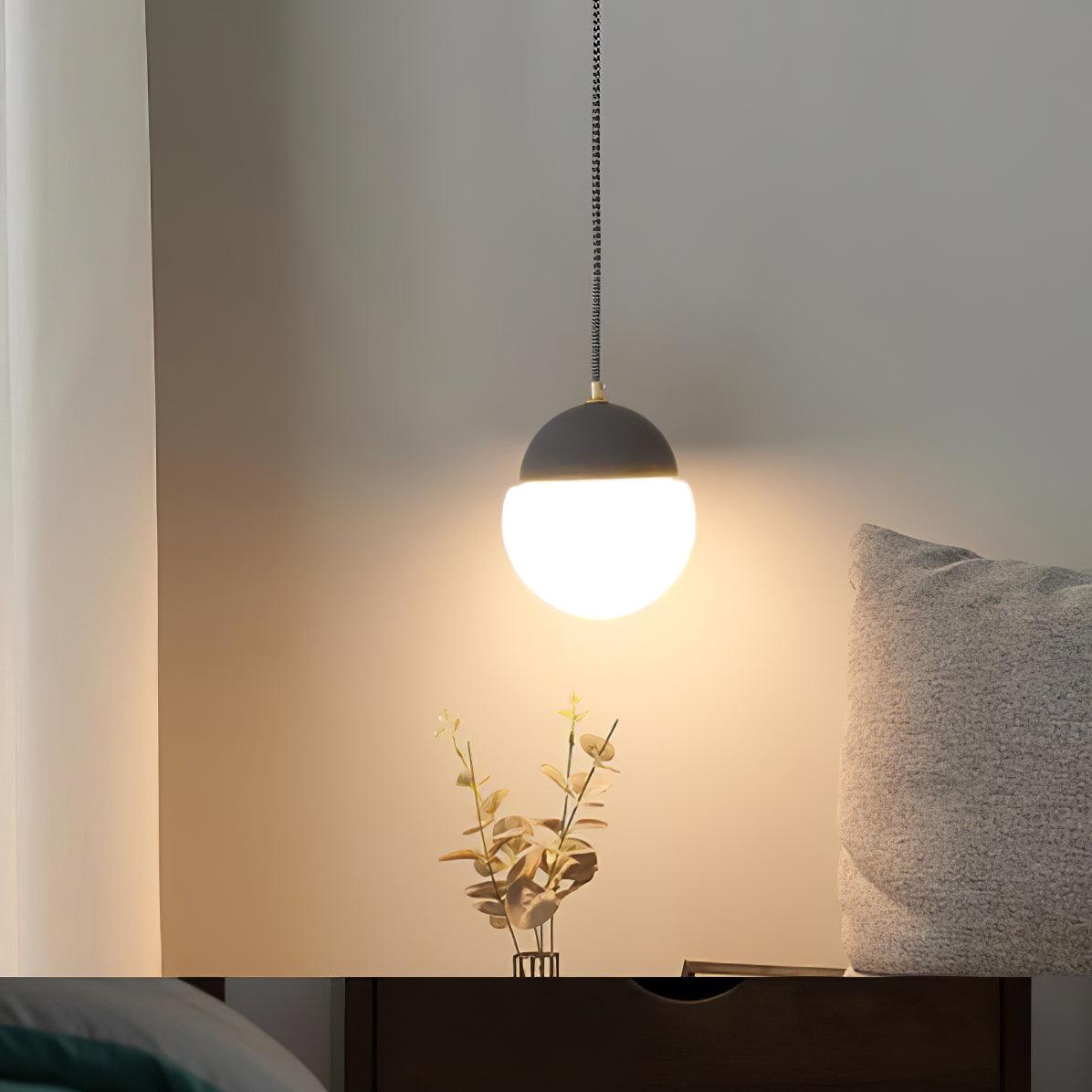 White globe pendant near bedside flowers