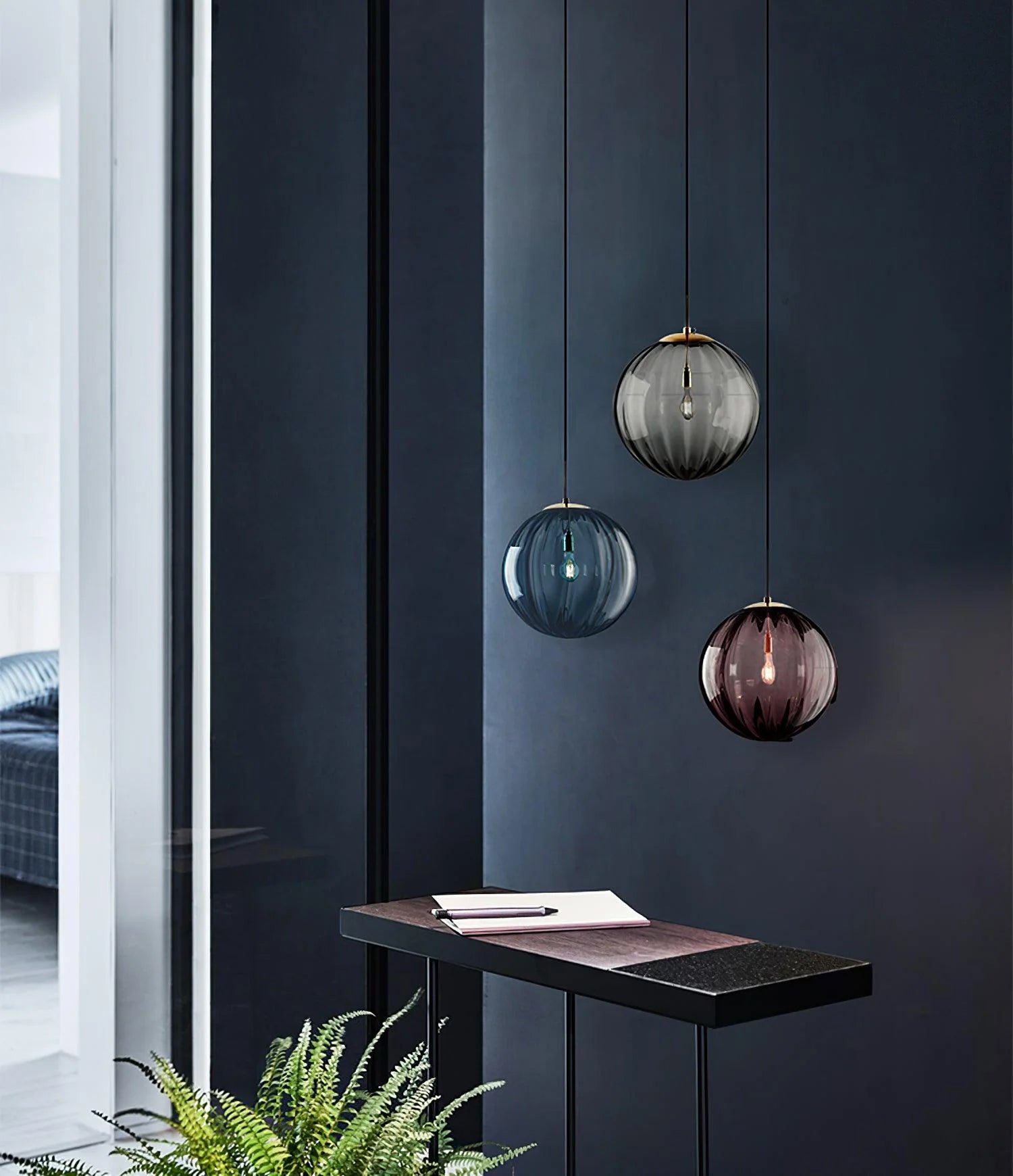 Paola pendant light with a coloured glass globe and small metal cap