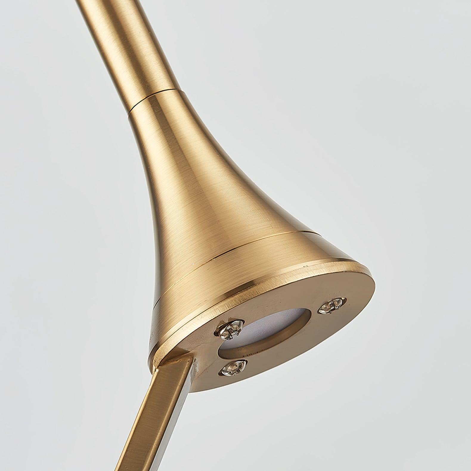 Underside of gold-toned flared lamp head with circular pale lens, three screws and attached diagonal support