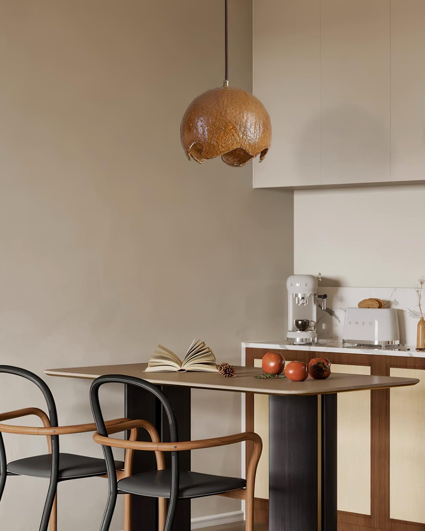 Brown globe pendant above a table near the kitchen