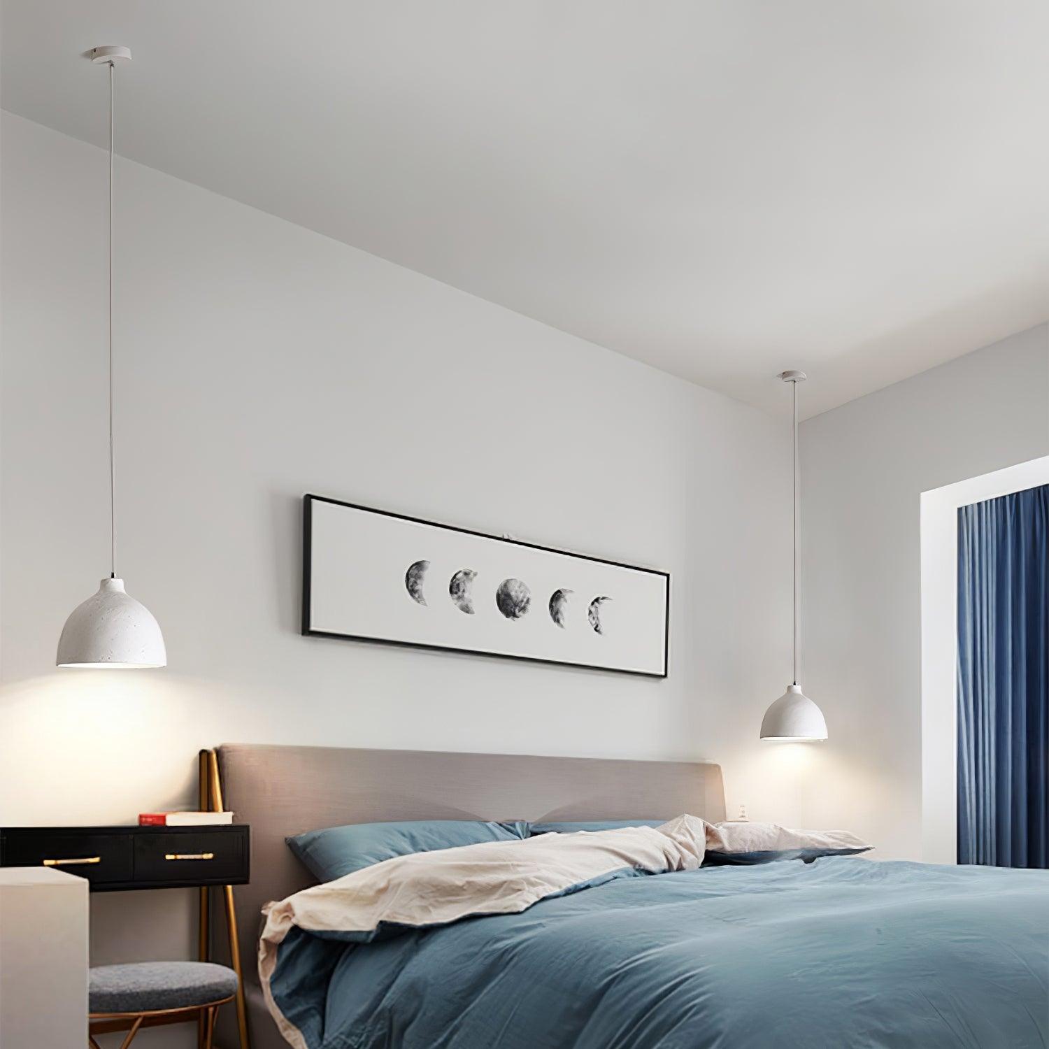 Pair of white pendants beside a bed