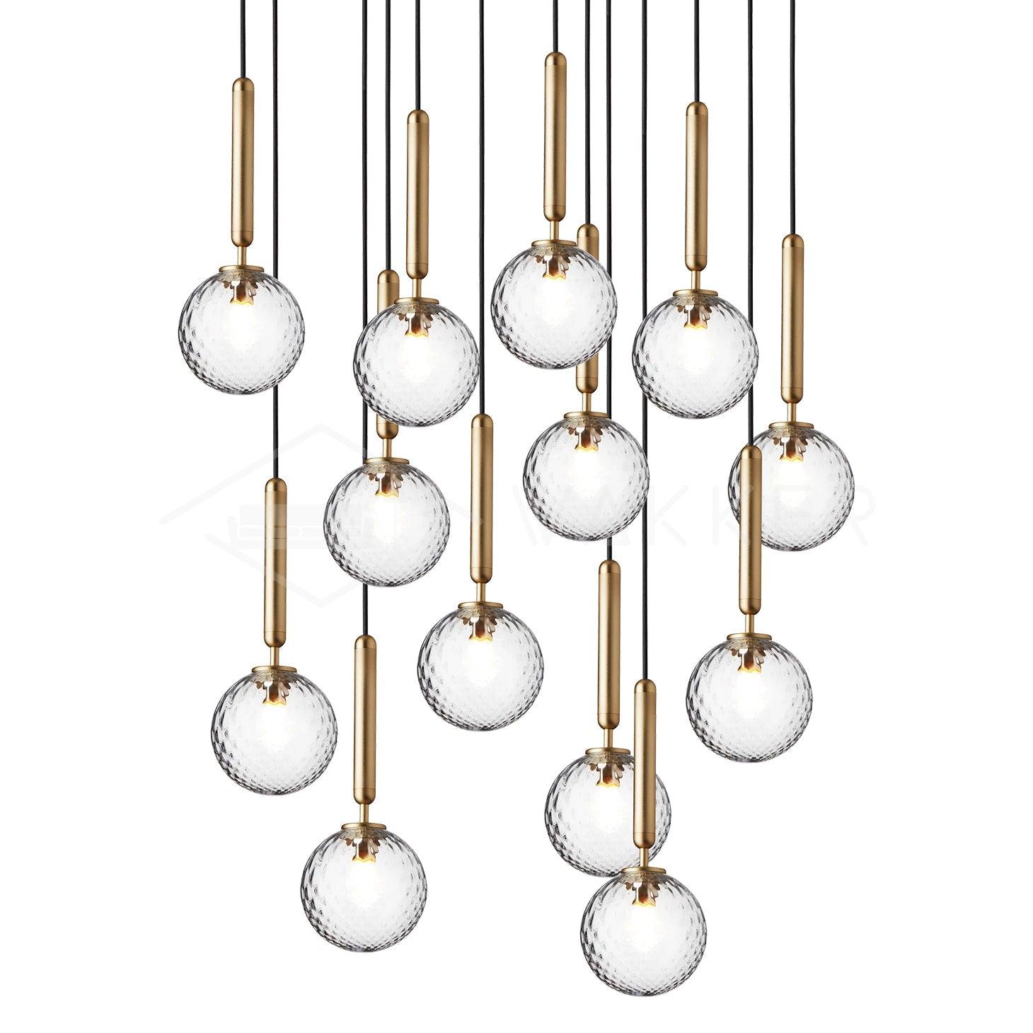 Long cascade of patterned clear glass globes with brass stems at staggered heights