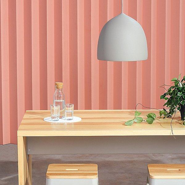 Grey bell pendant over a wooden dining table