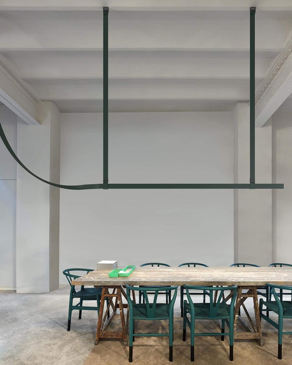 Dark green Belt profile suspended above a long table and green chairs
