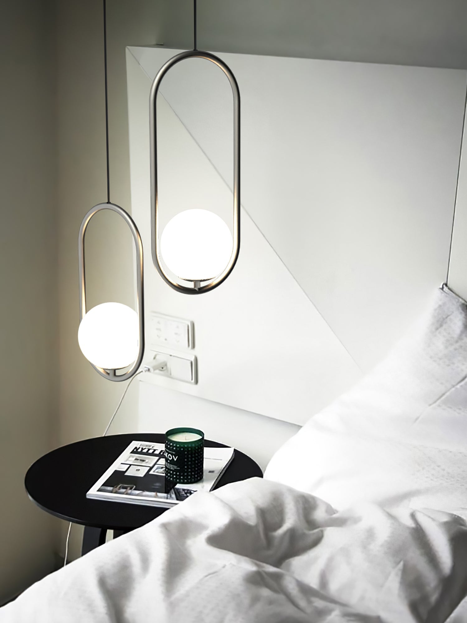 Two oval pendant frames beside a bed