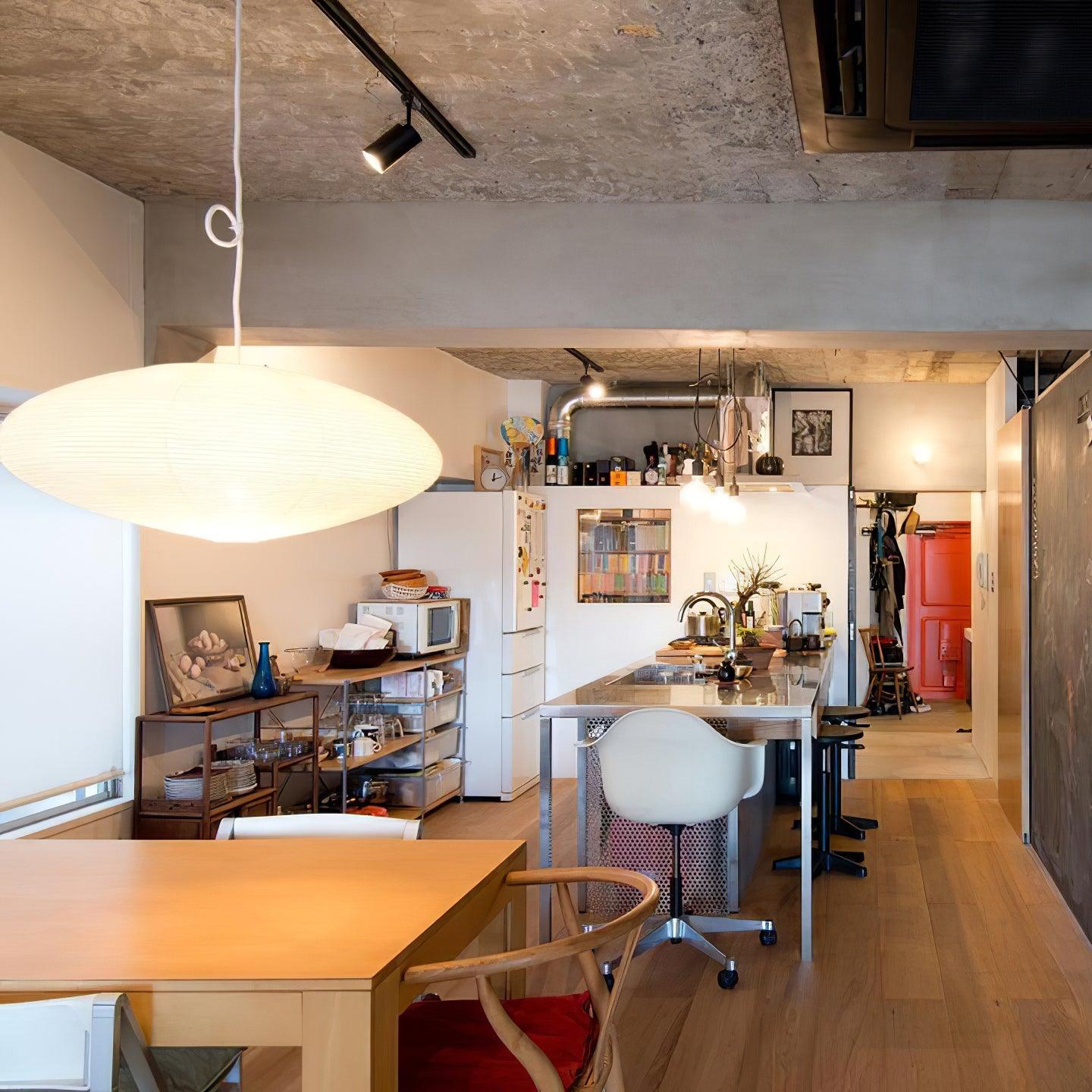 Broad paper swag lamp above a dining table