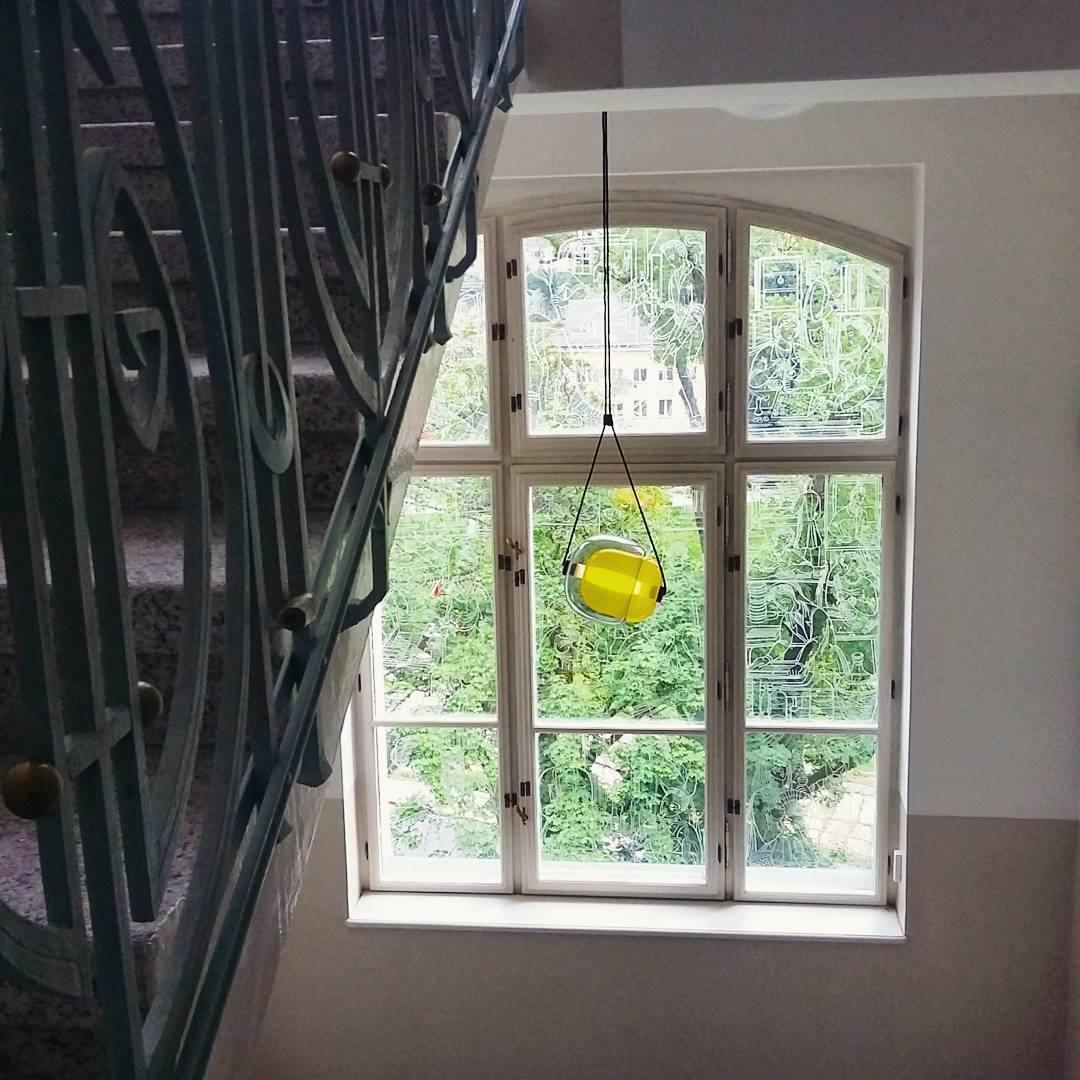 Yellow glass pendant beside a tall window
