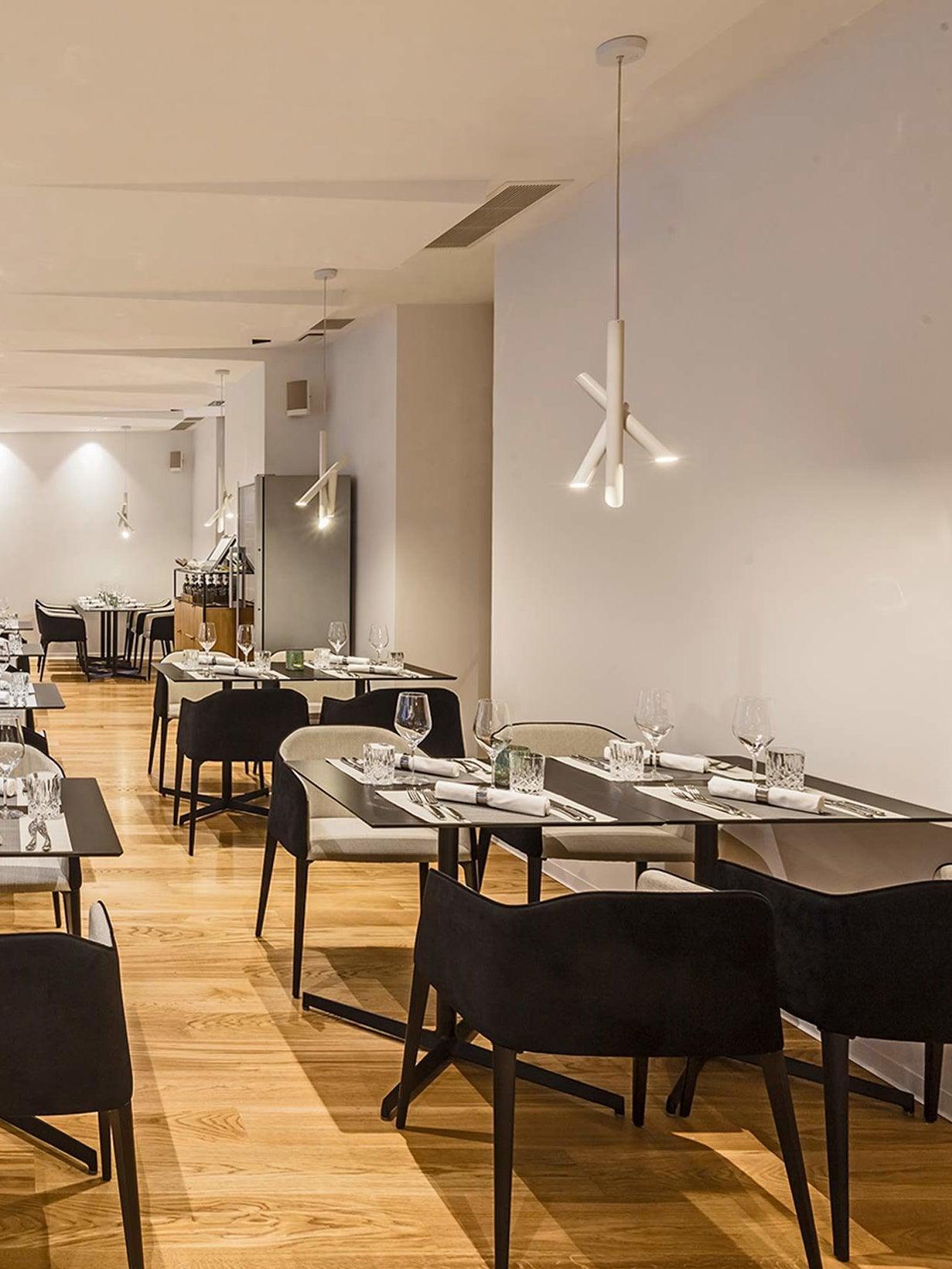 White Tubes pendants along a restaurant interior with dining tables and chairs
