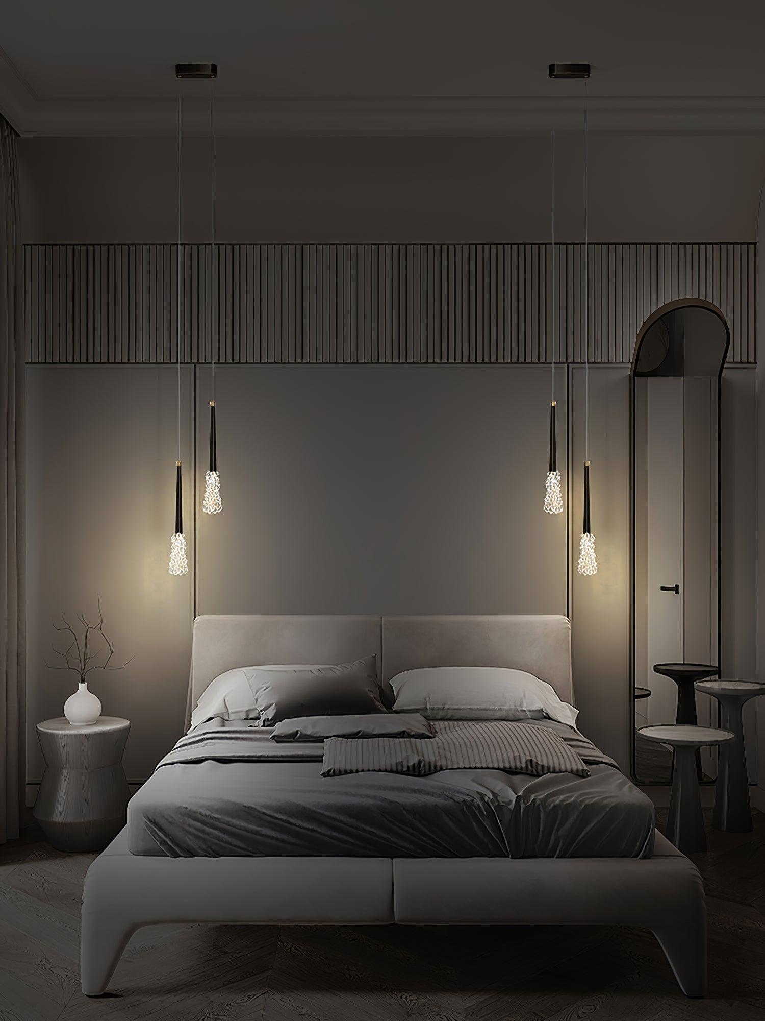 Dark-finish pendants shown beside a bed