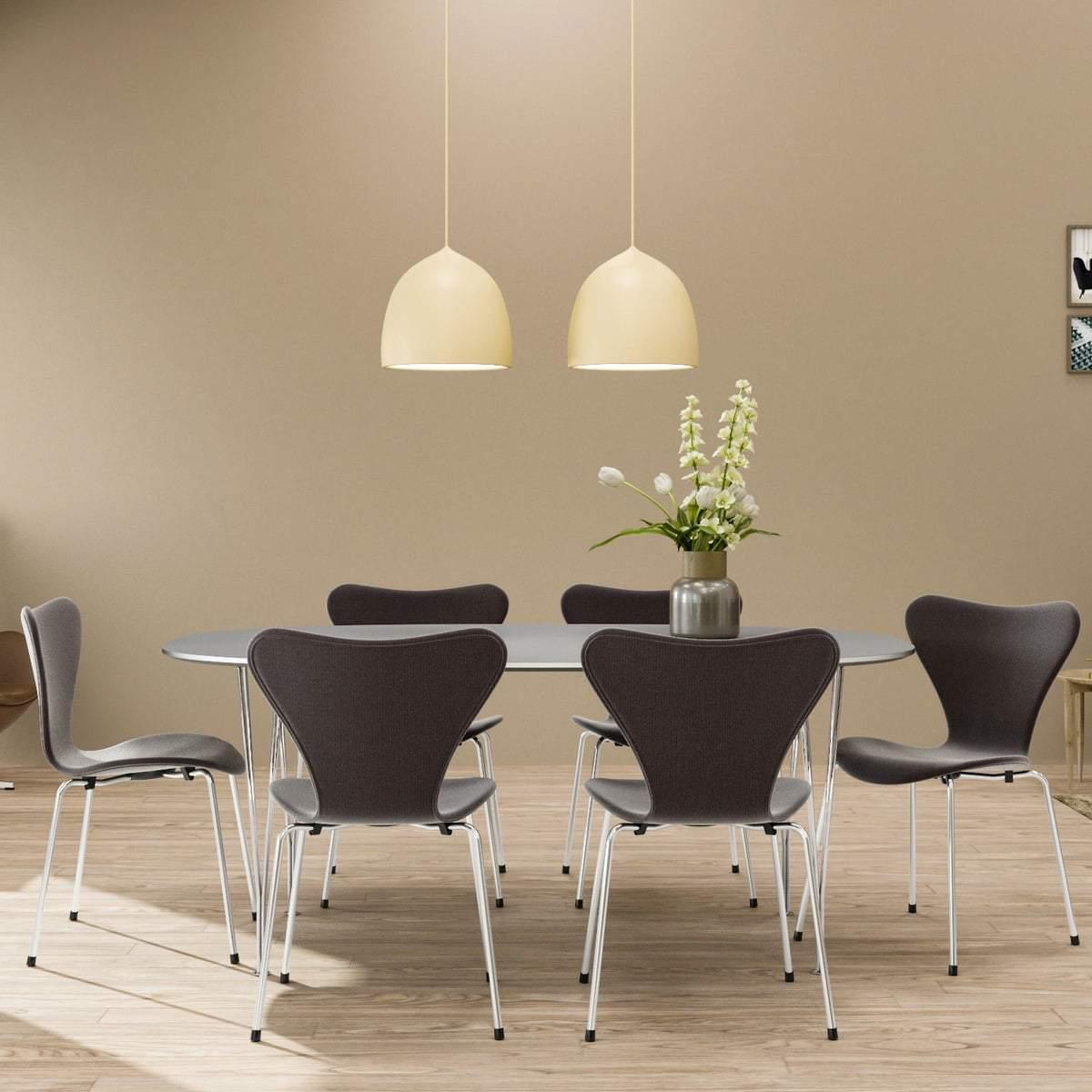 Two white pendants above a dining table and chairs