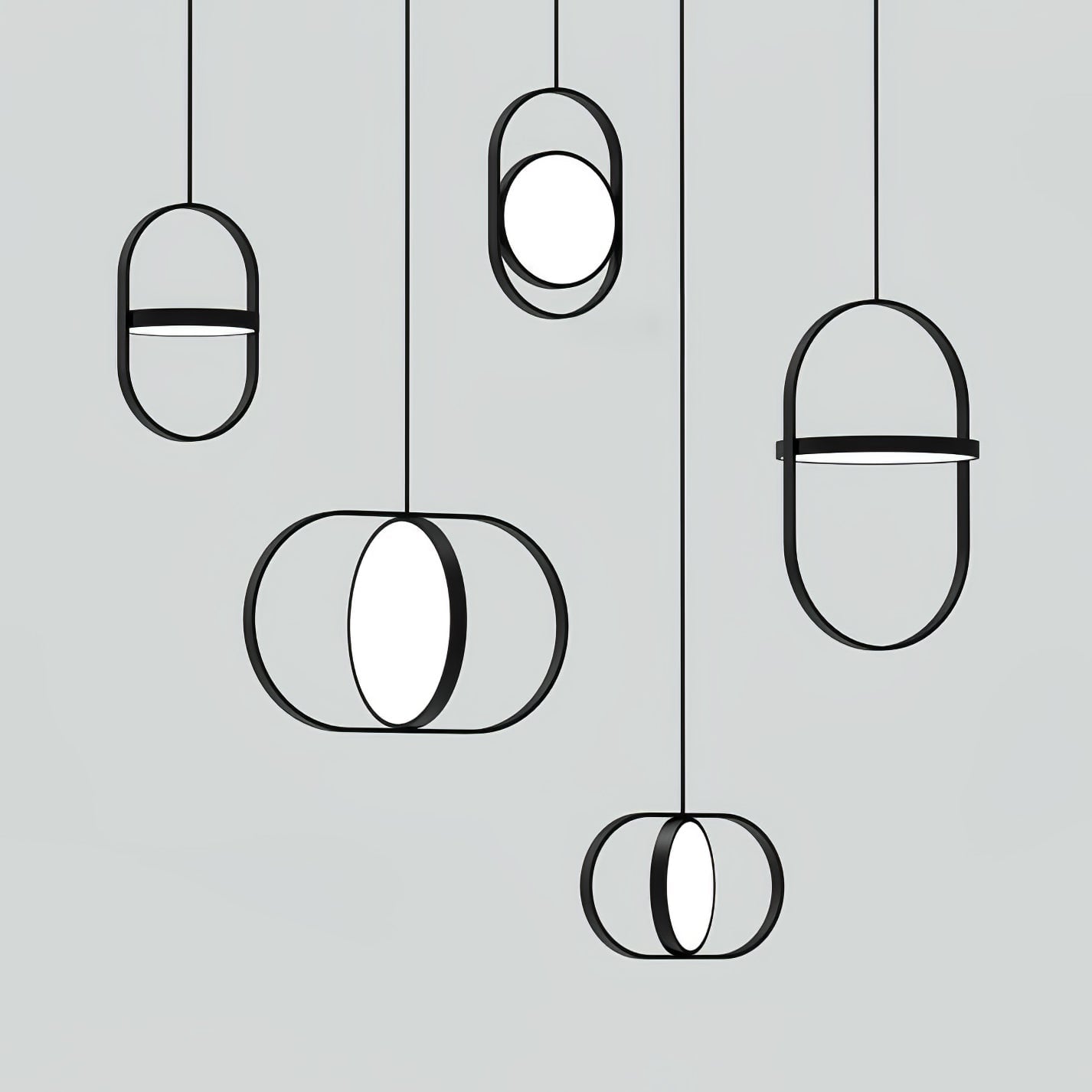 Four black KUU pendants showing forward-facing and edge-on inner discs