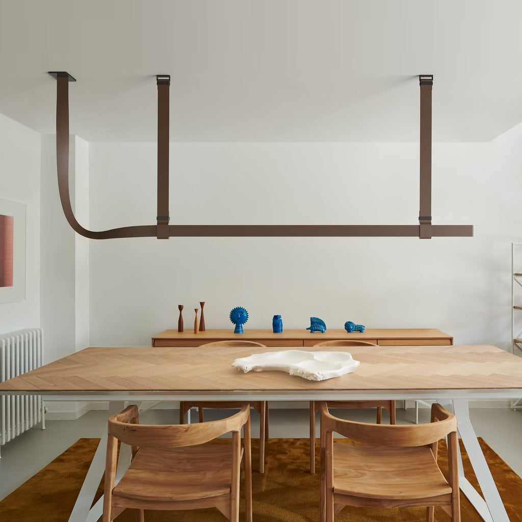 Brown leather-strap fixture over a wooden table
