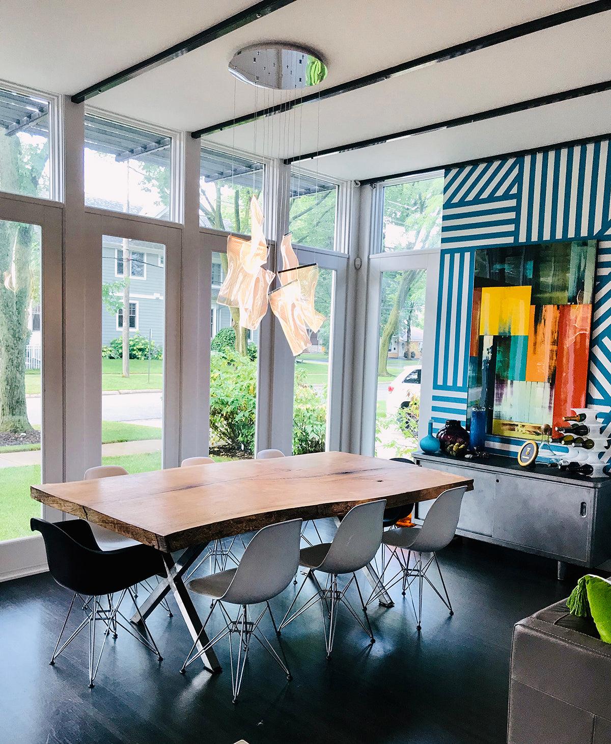 Acrylic pendant group over a dining table by large windows