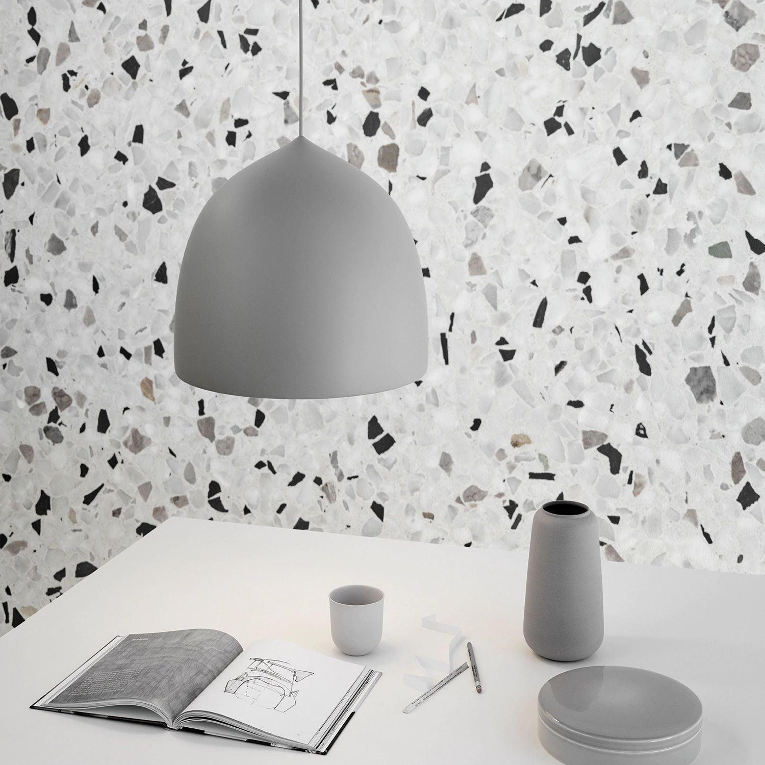 Grey bell shade above a table against a patterned wall