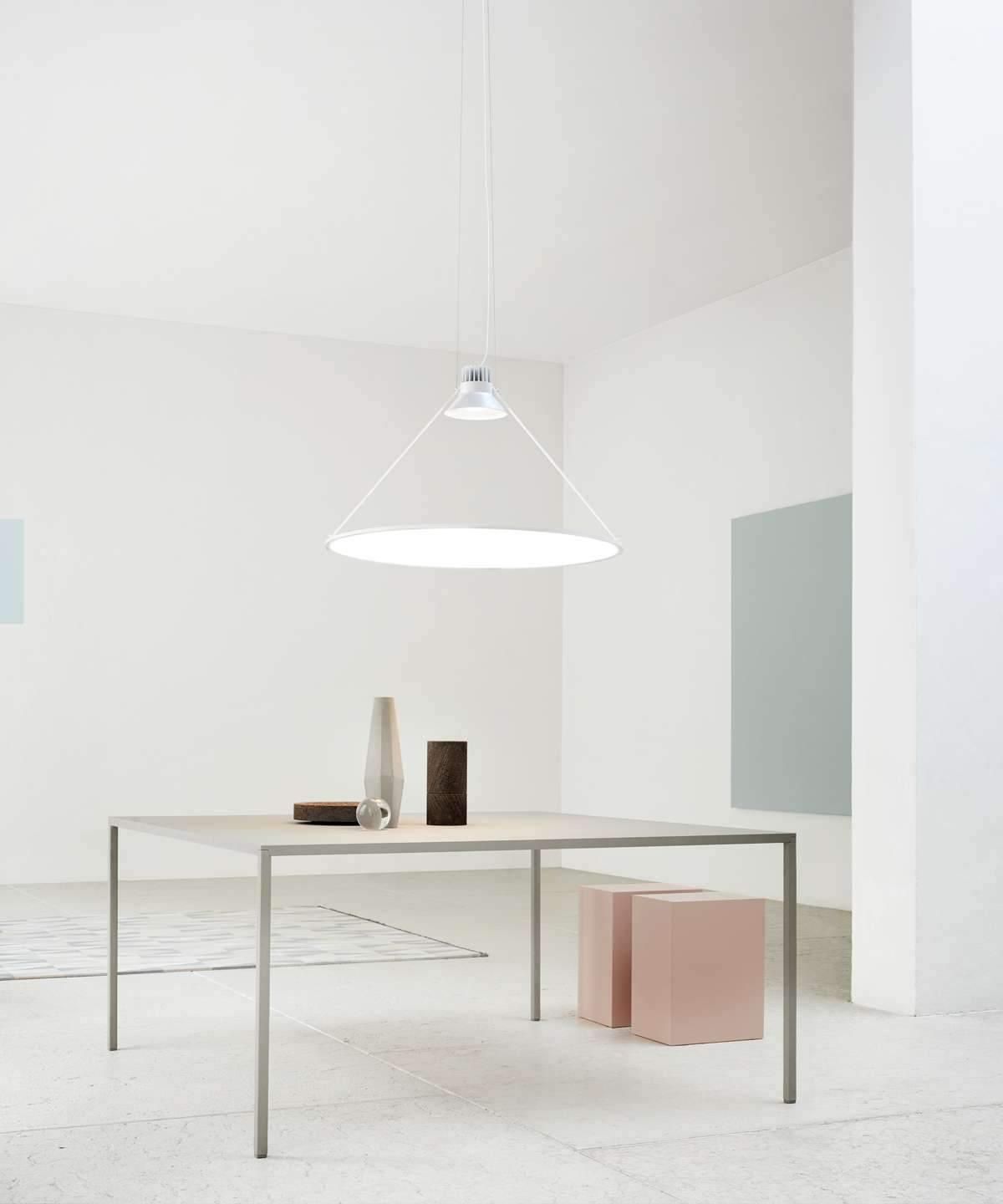 White horizontal disc pendant above a dining table