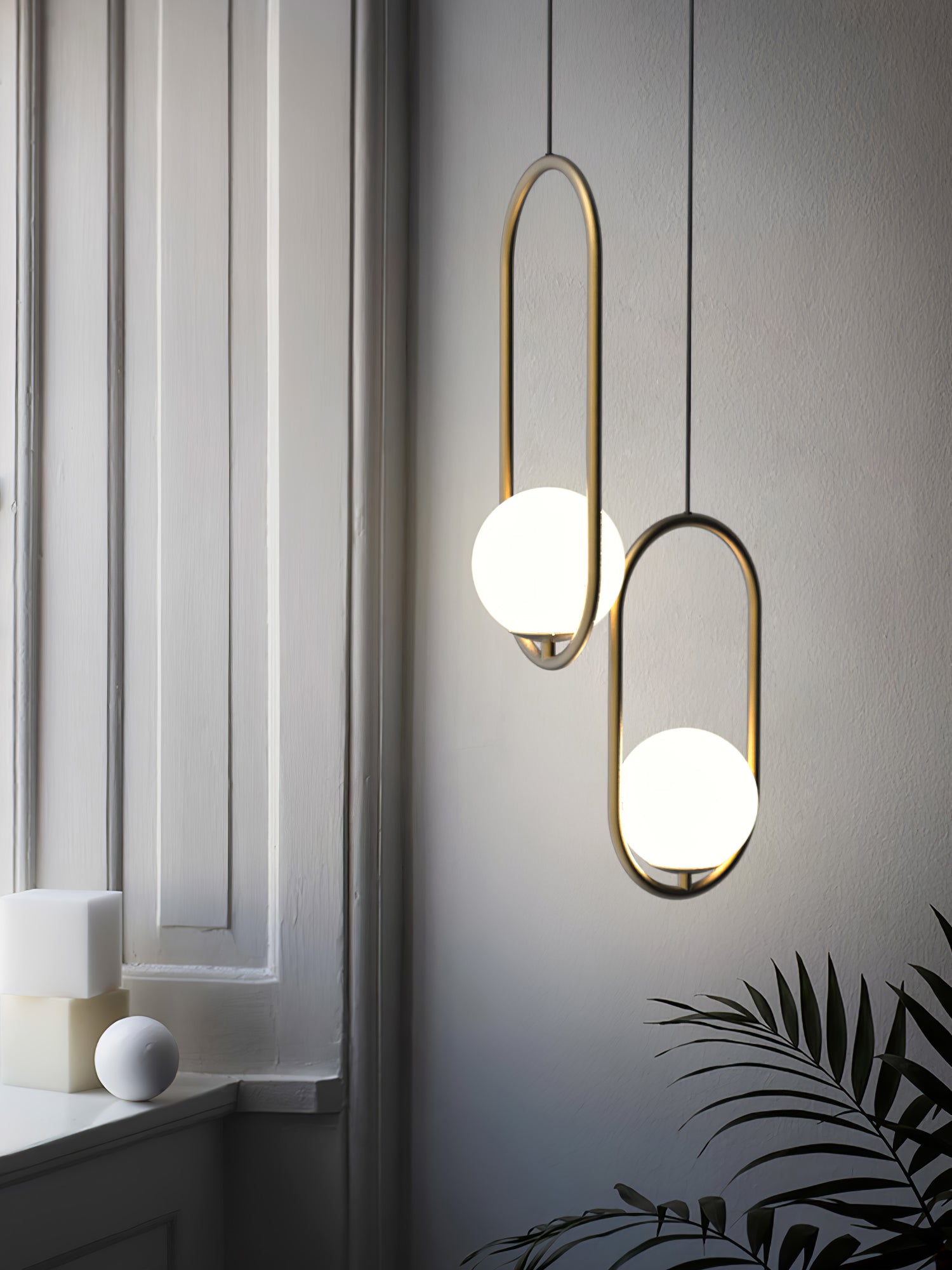 Two oval frame pendants beside a window