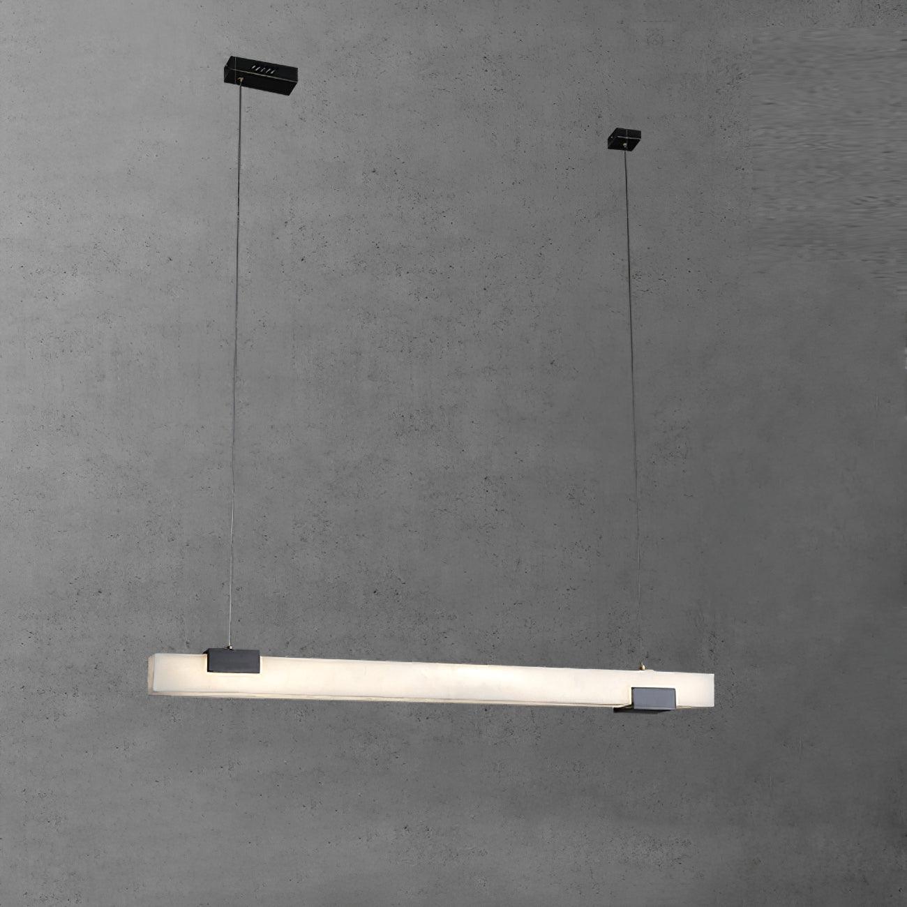 White linear pendant on long thin cables with two separate black canopies against a grey textured wall