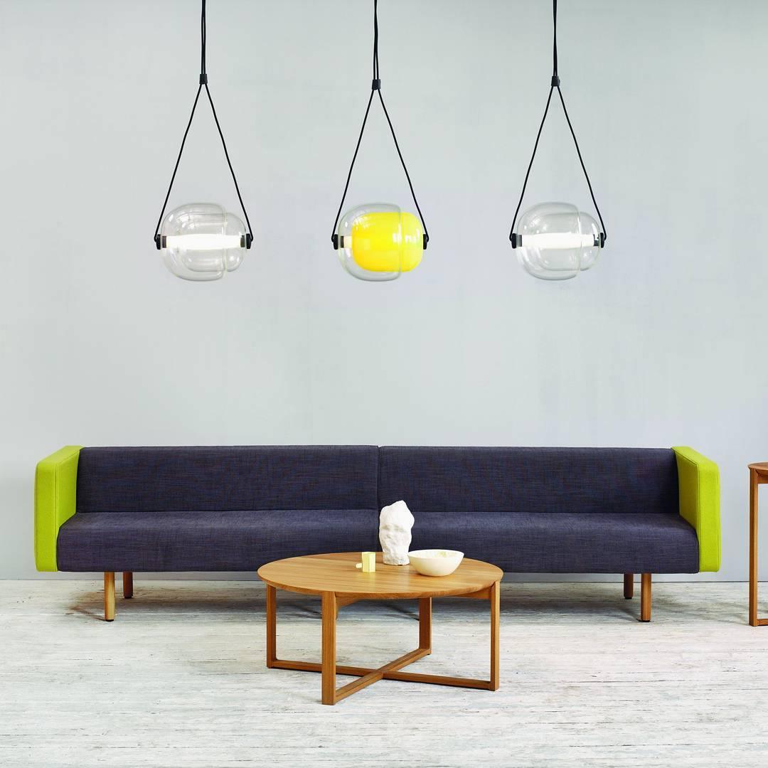 Three glass capsule pendants above a sofa