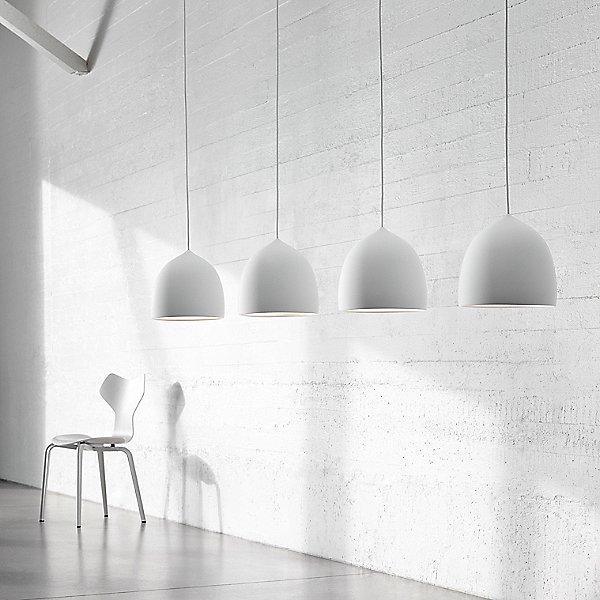 Row of four white bell pendants against a pale wall