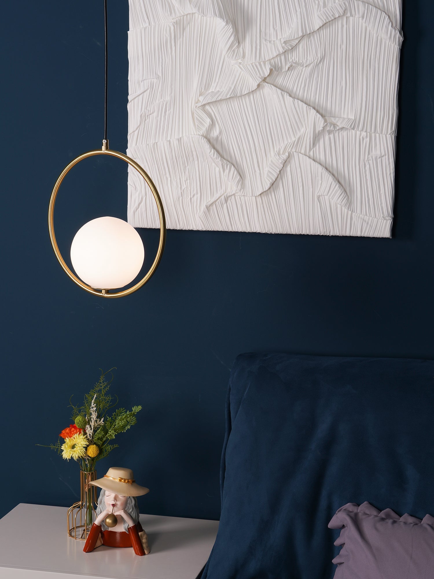 Circular brass-coloured frame and globe above a blue sofa