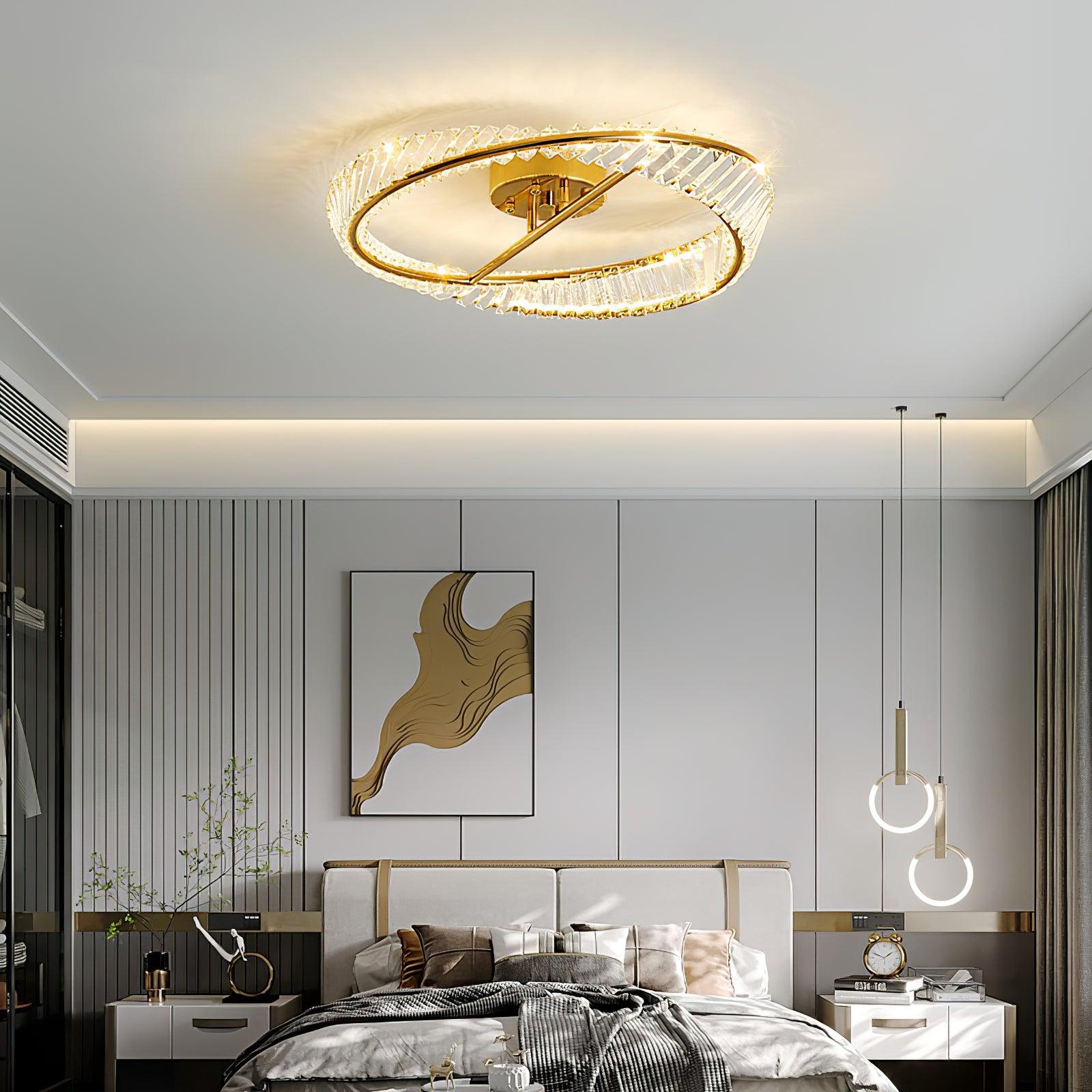 Illuminated glass ring ceiling light above a bed with separate hanging ring lights at the bedside