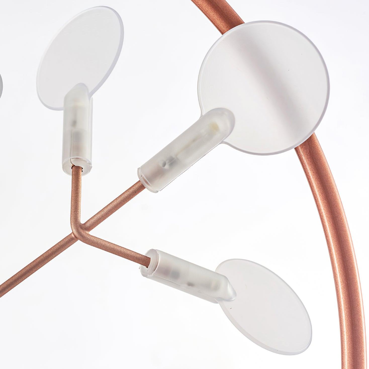 Close-up of unlit white round leaf disks and translucent sleeves on rose-copper branching rods