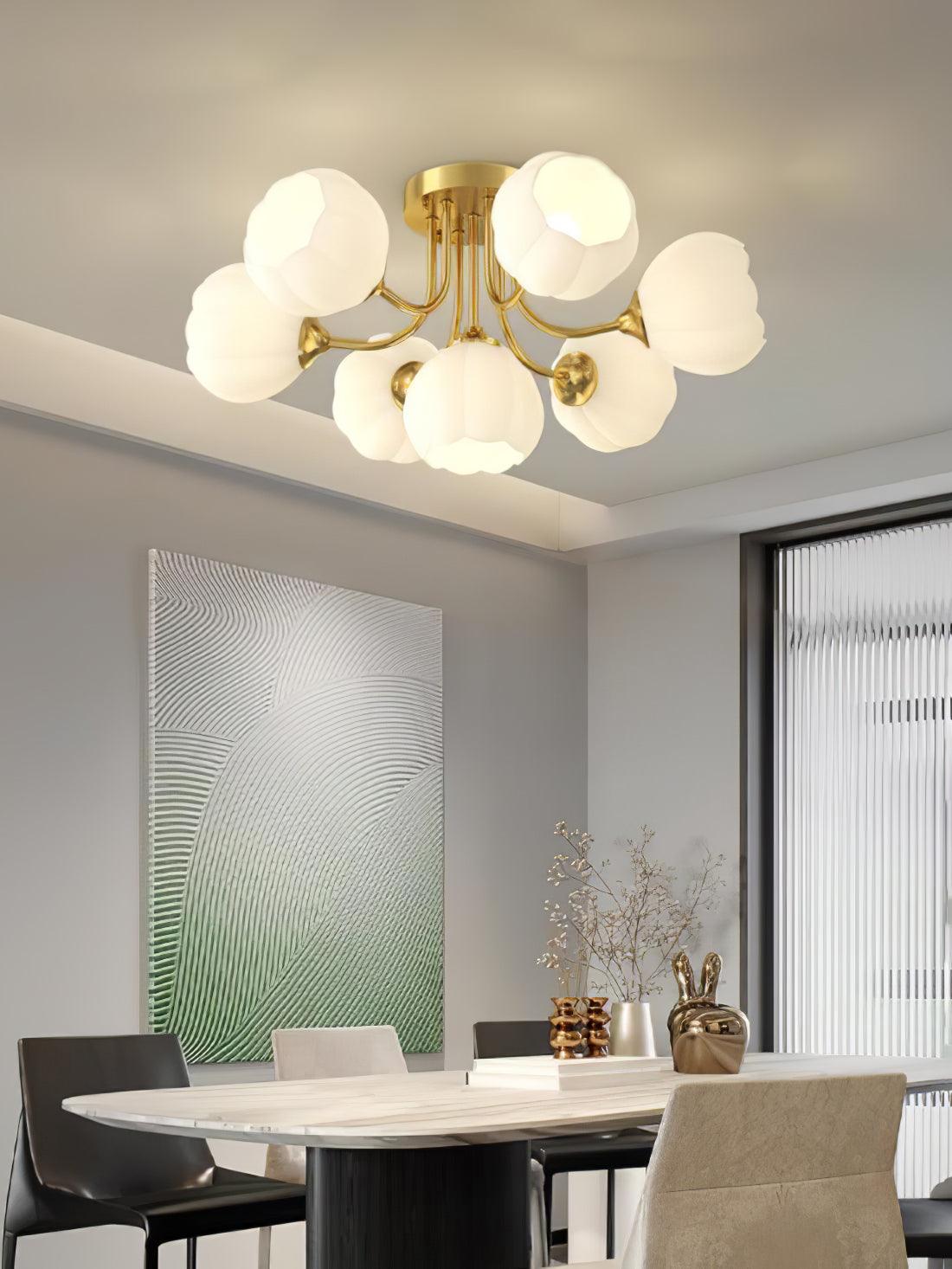 Brass-colour Pumpkin ceiling light with white glass shades above a marble-pattern dining table