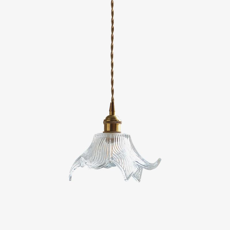 Unlit complete clear petal pendant with small brass-toned holder and long twisted tan cord against white.