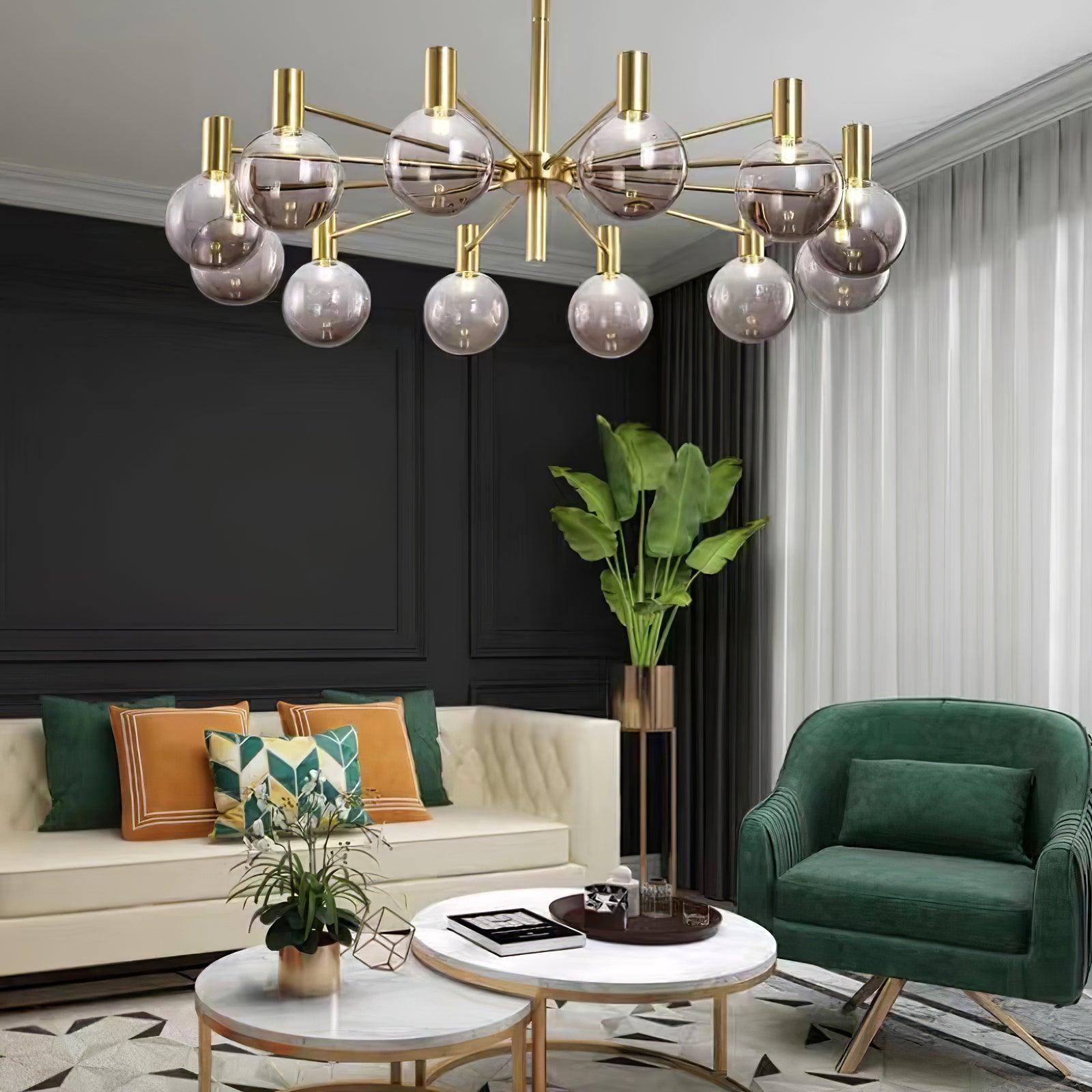Clear-globe chandelier above a cream sofa, green armchair and paired white tables, beside dark panels and white sheers.