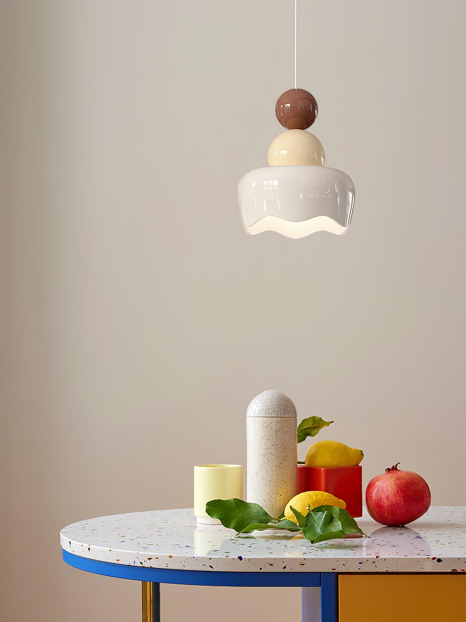 White wavy shade and stacked rounded forms above a table