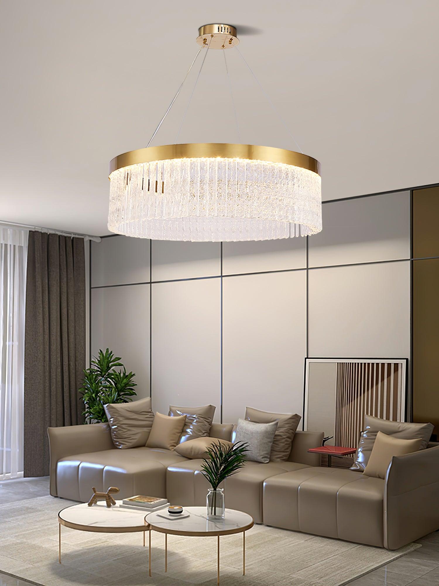Illuminated crystal ring above taupe sofa with shiny pale cushions, two round coffee tables and grid-pattern wall