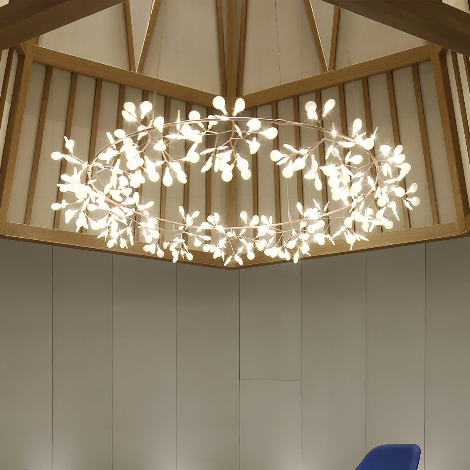 Broad pale metallic leaf ring chandelier beneath exposed timber roof beams above a blue chair