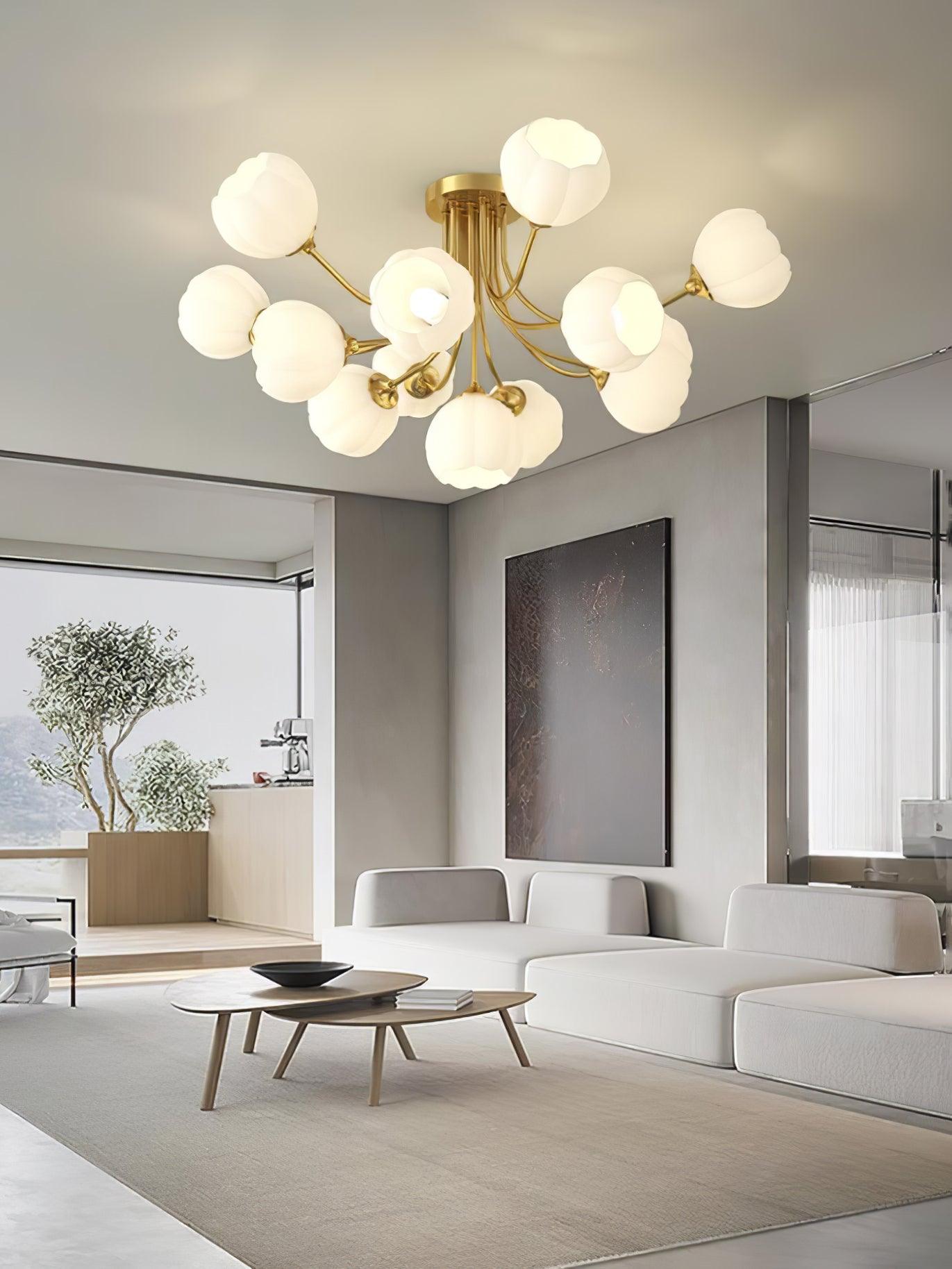 Brass-colour Pumpkin ceiling light above a white sofa, nested wood tables and framed artwork